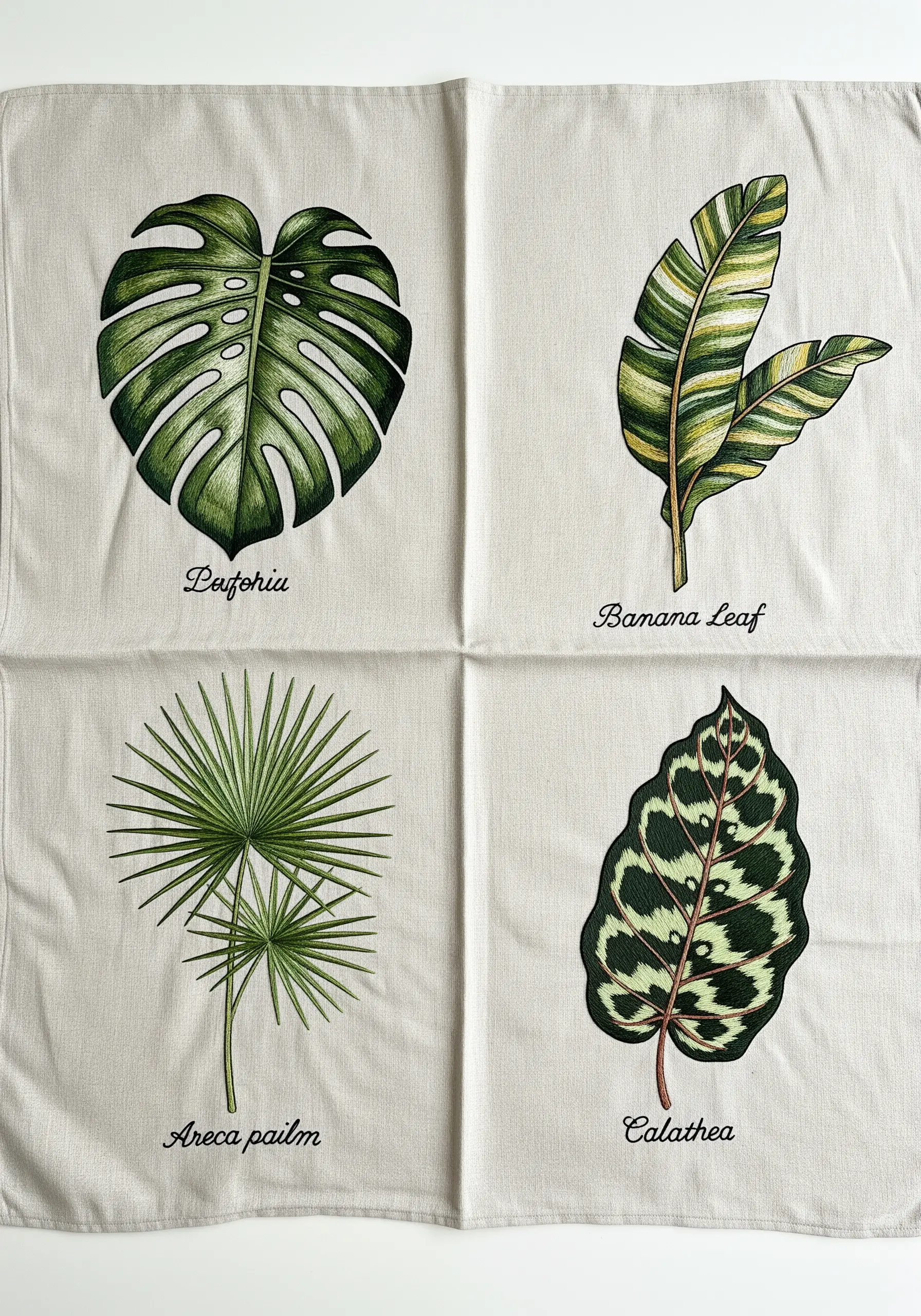 A fabric sampler with four different embroidered leaves, each in a vintage botanical illustration style.