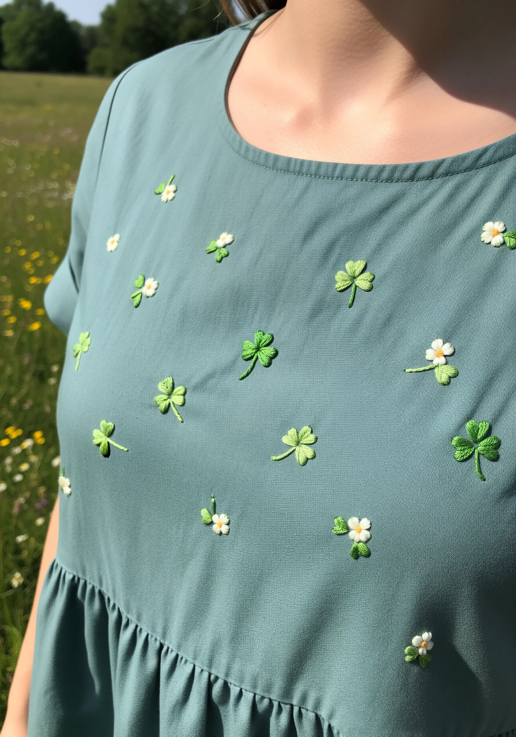 Small, scattered clover and micro-flower embroidery on a dusty blue dress.