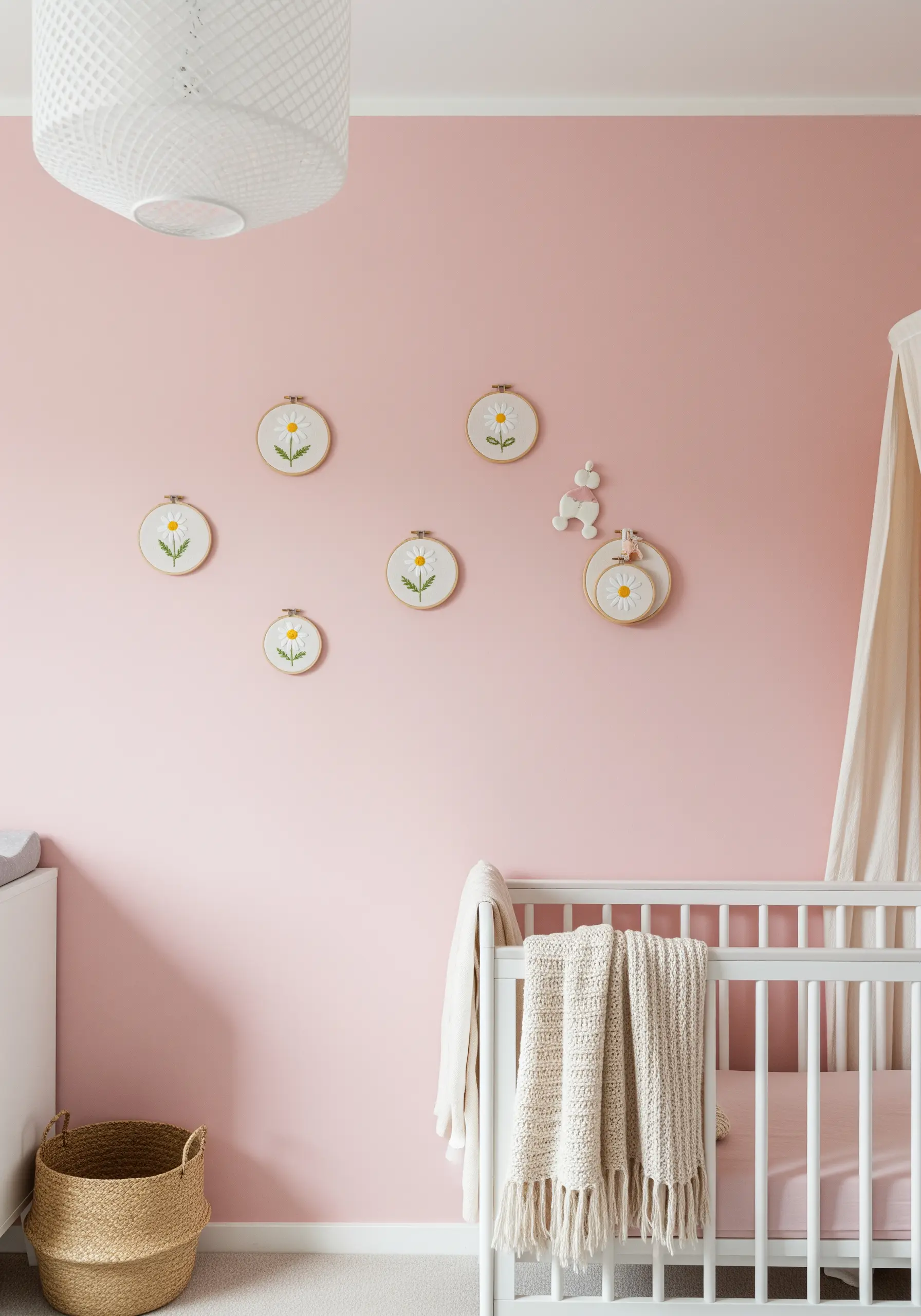 A scattered collection of small embroidery hoops with simple daisy motifs on a pink wall.