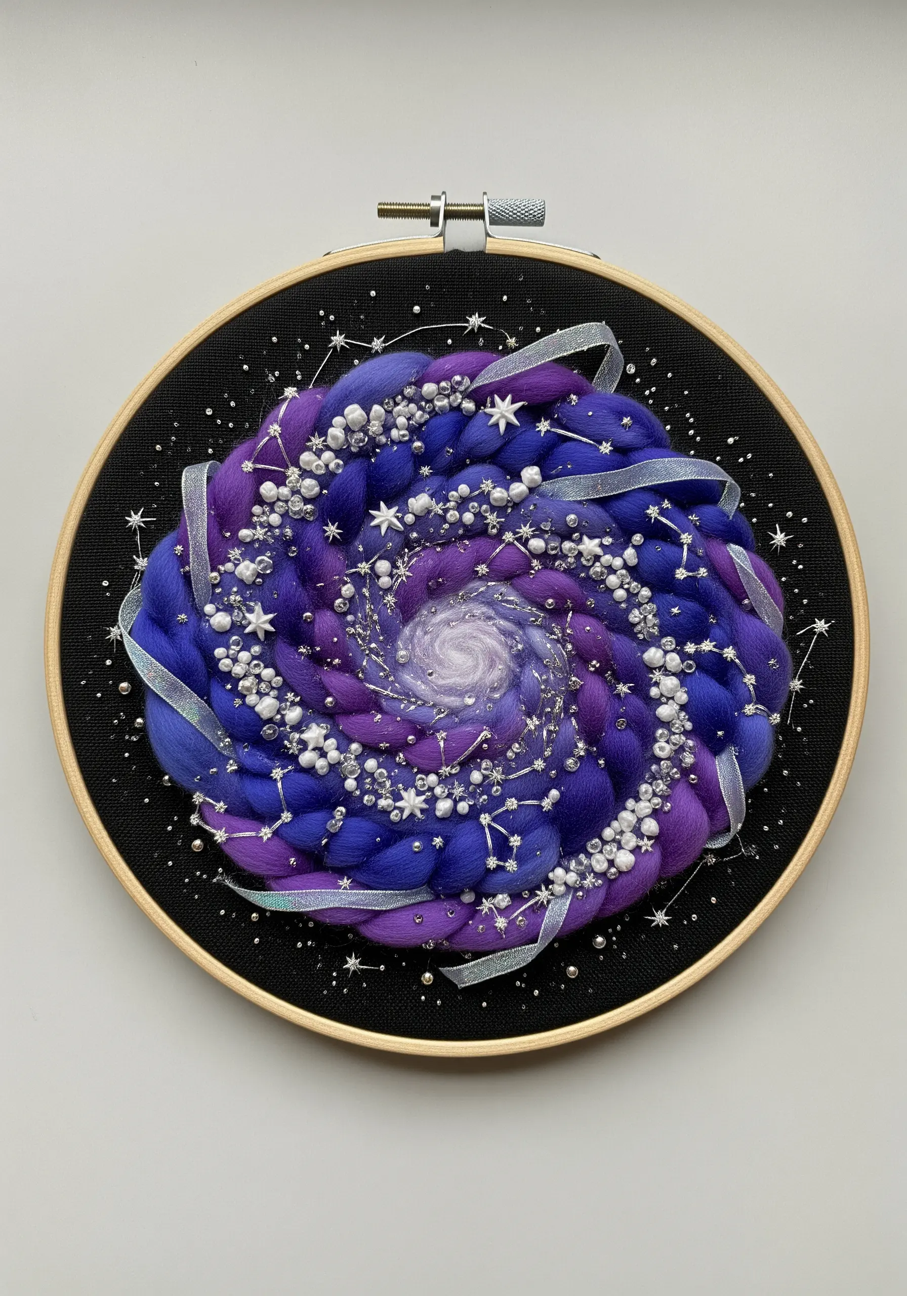 Cosmic galaxy embroidery with purple wool roving, ribbon, and beads in a hoop.