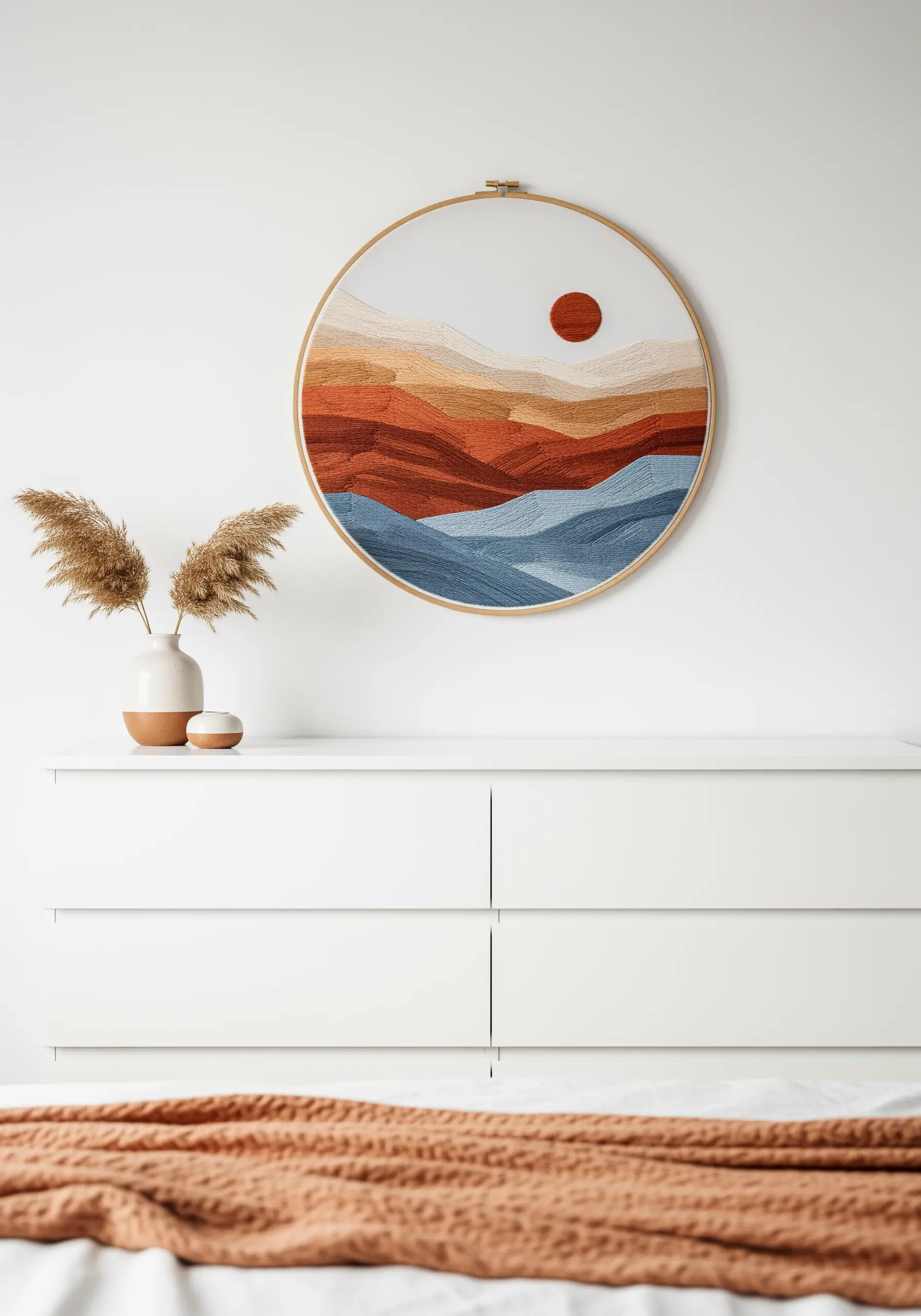 Large embroidery hoop with an abstract landscape in earthy tones of red, orange, and blue.