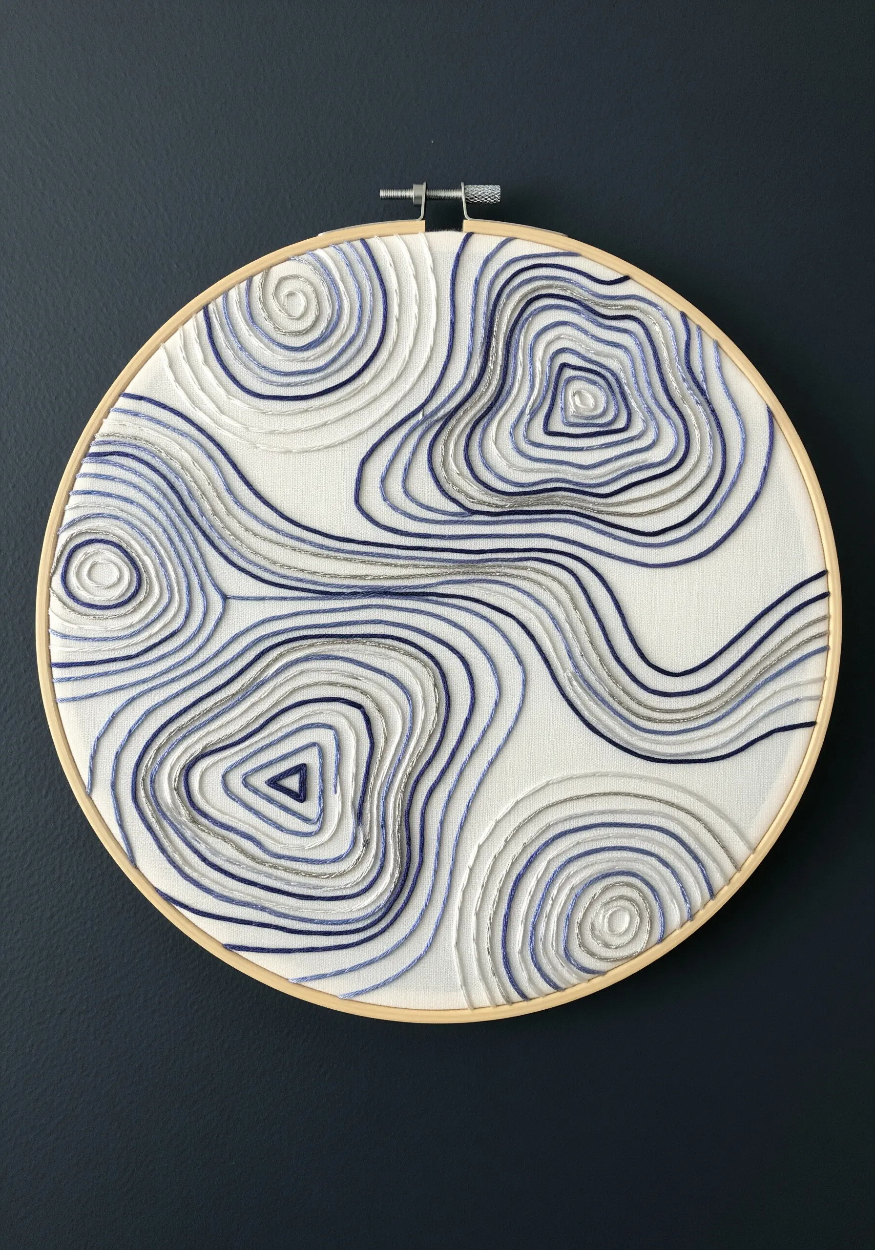 Abstract water ripple embroidery using raised, whipped stem stitch for a 3D effect.