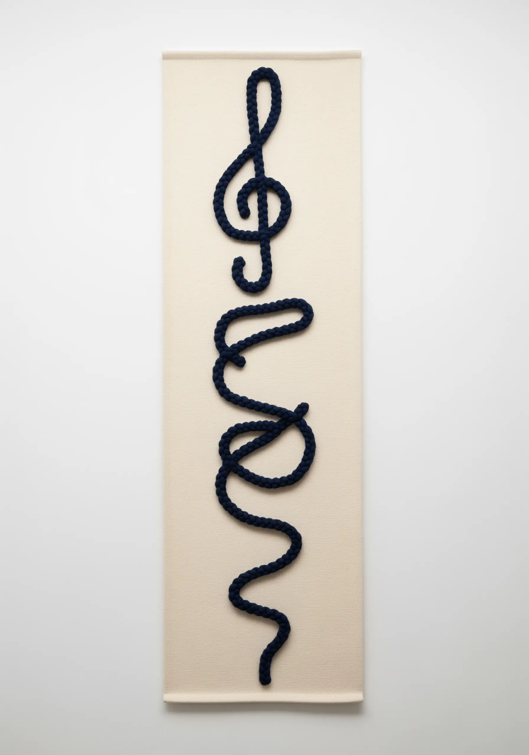 A minimalist wall hanging with a thick, dark rope couched into a musical shape.