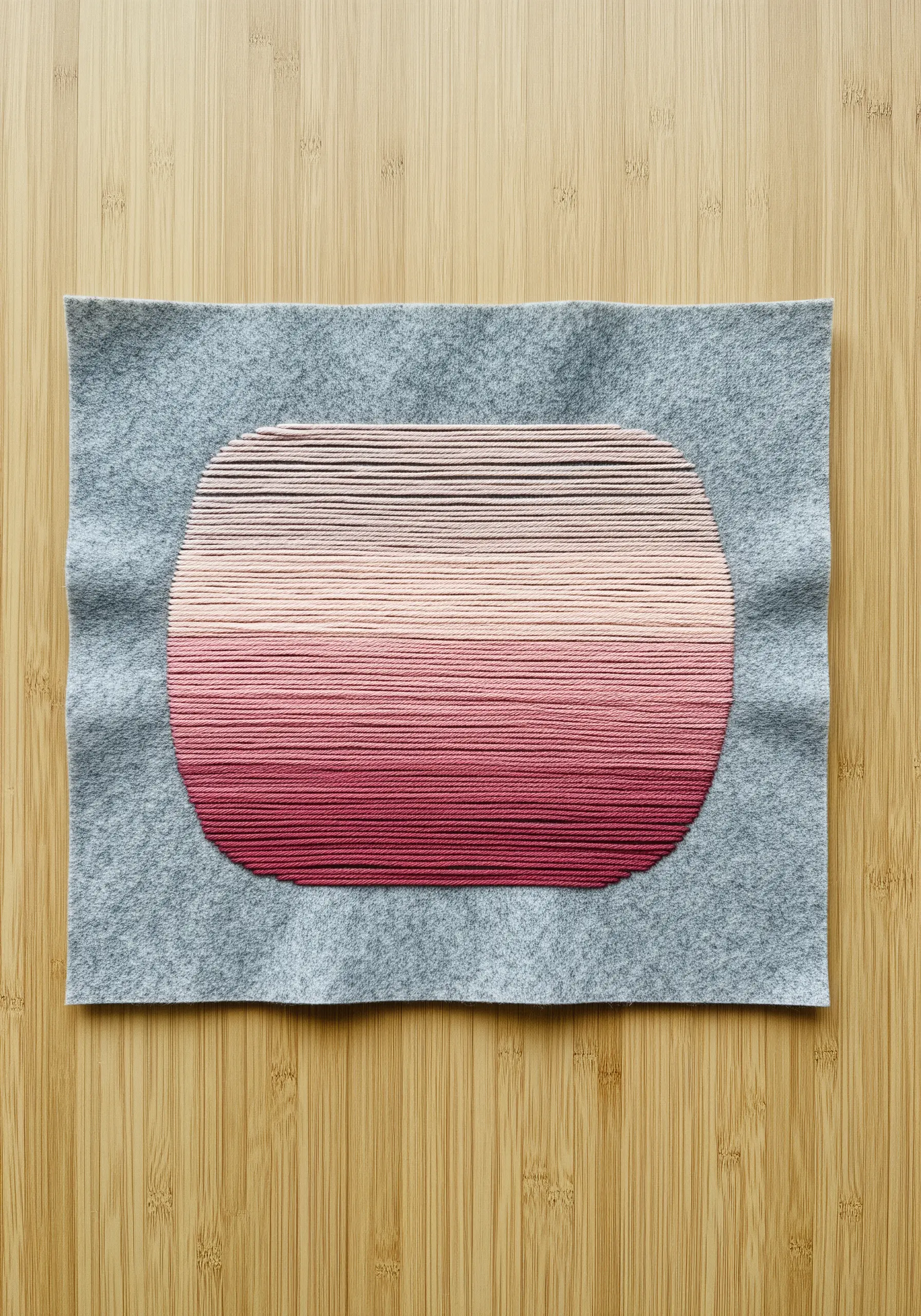 A pink and red ombré gradient embroidered inside a rounded rectangle shape.