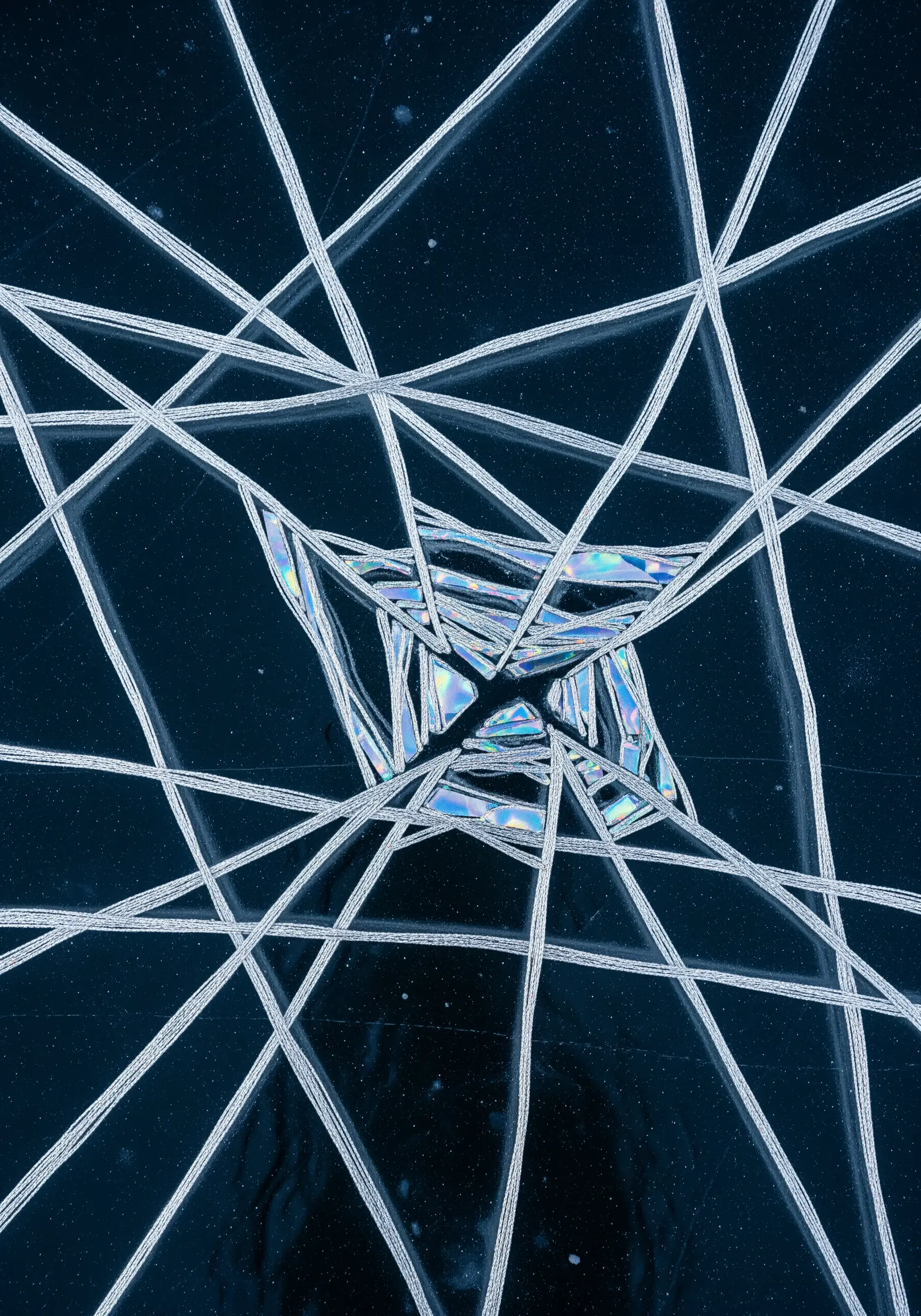 Abstract design with iridescent appliqué and silver metallic straight stitches.