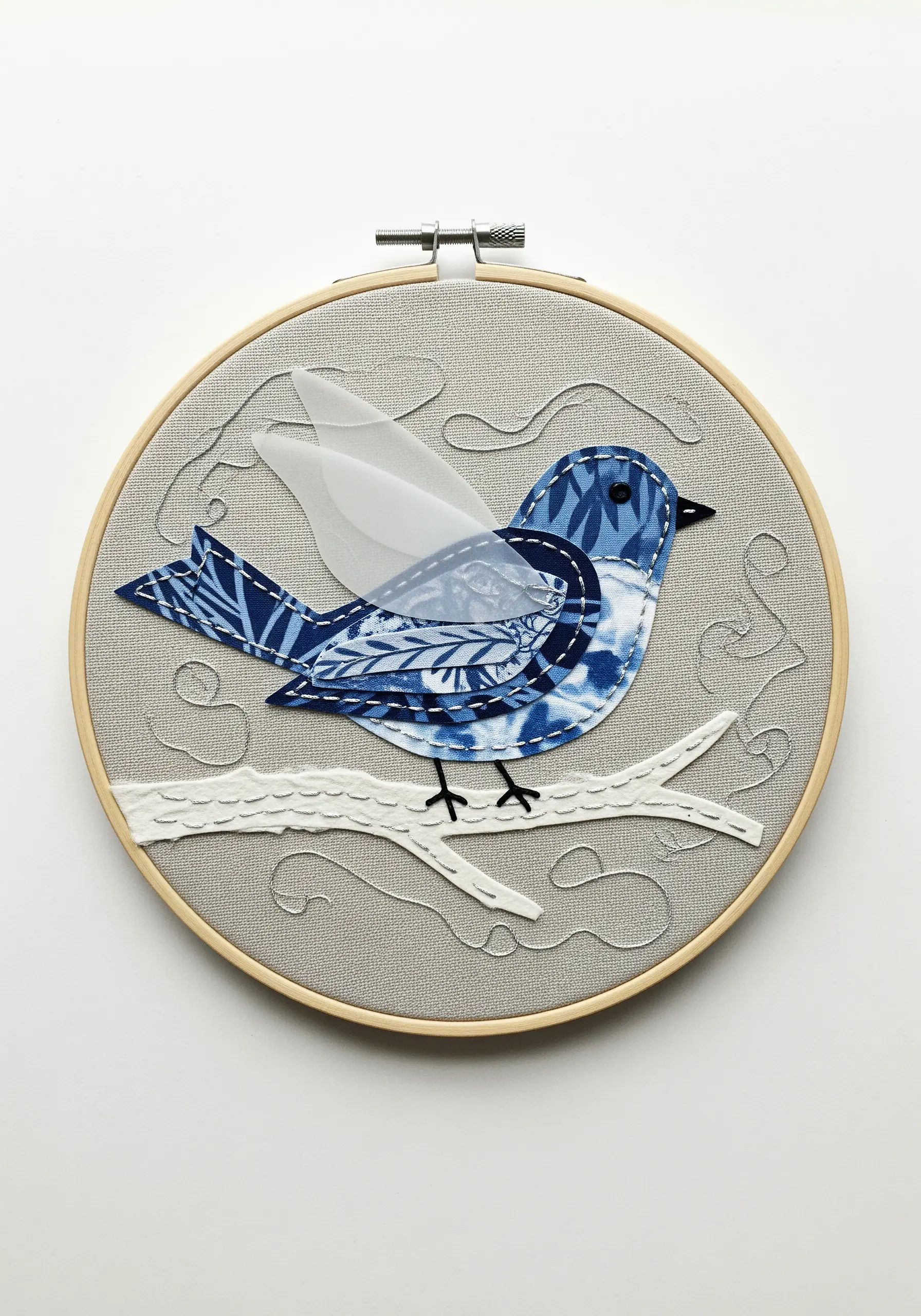 Fabric appliqué bird with a sheer organza wing, stitched in a hoop.