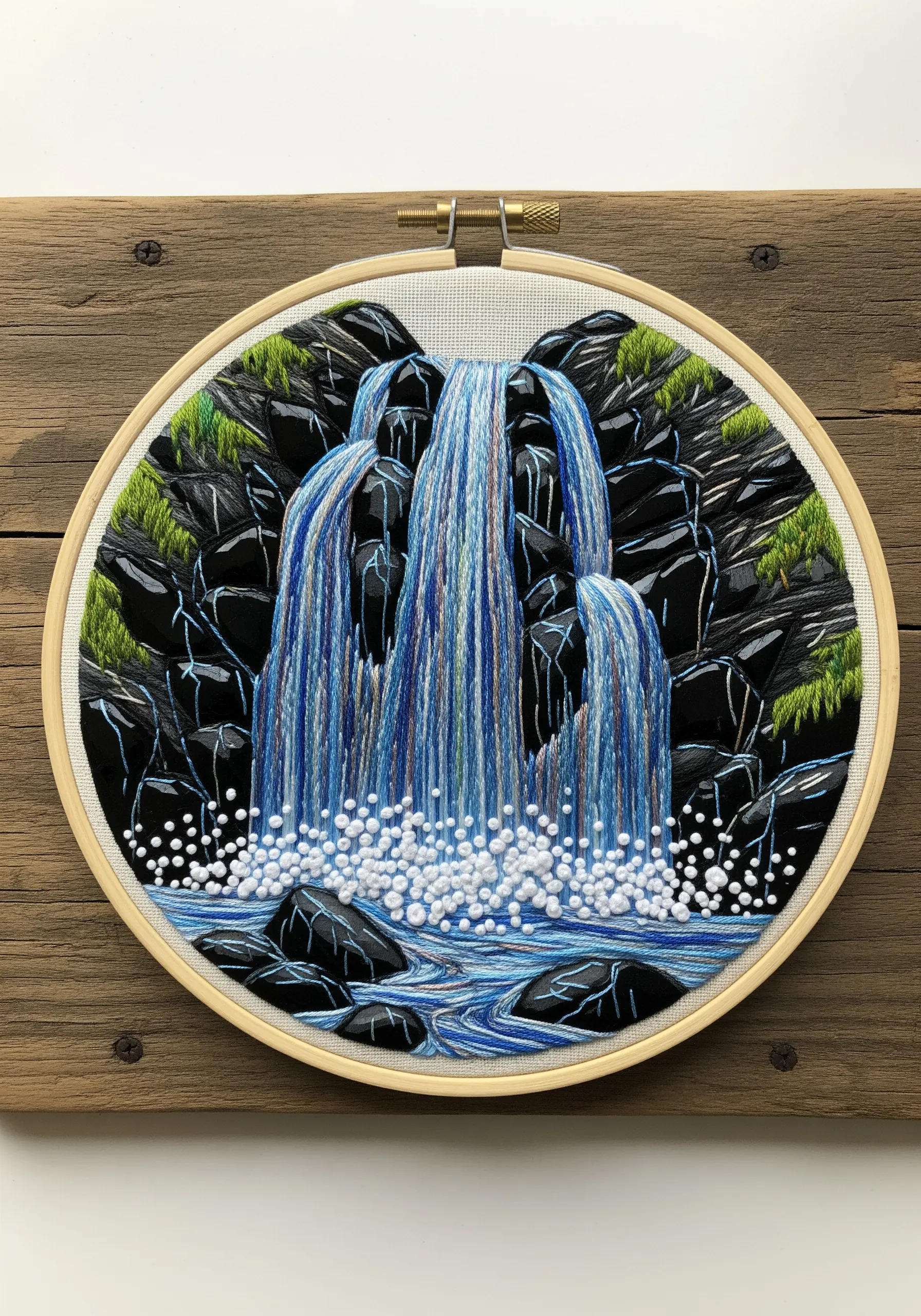 Embroidery of a cascading waterfall with blended vertical stitches and French knot spray.