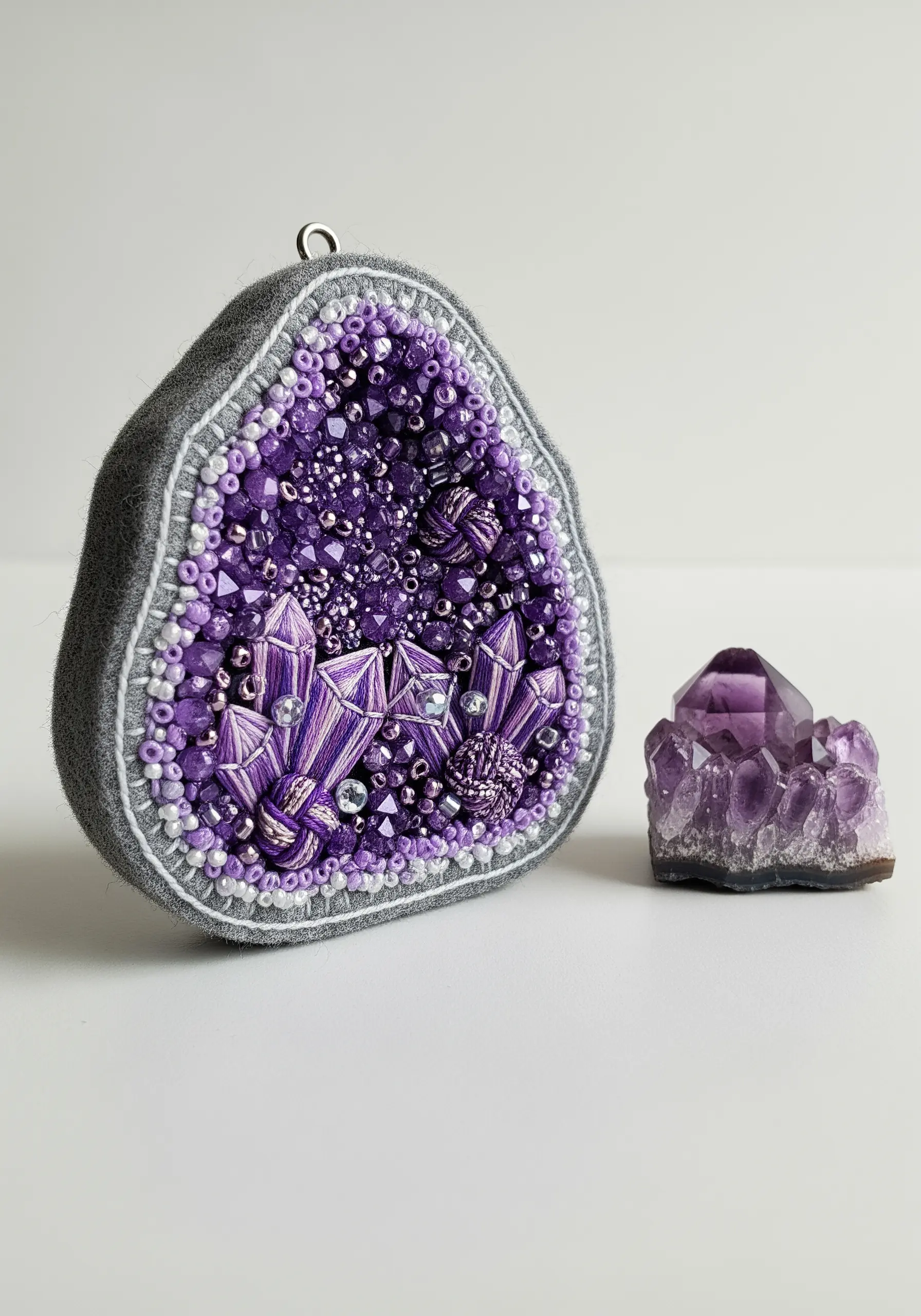 Textural embroidery and beading art piece mimicking an amethyst geode.