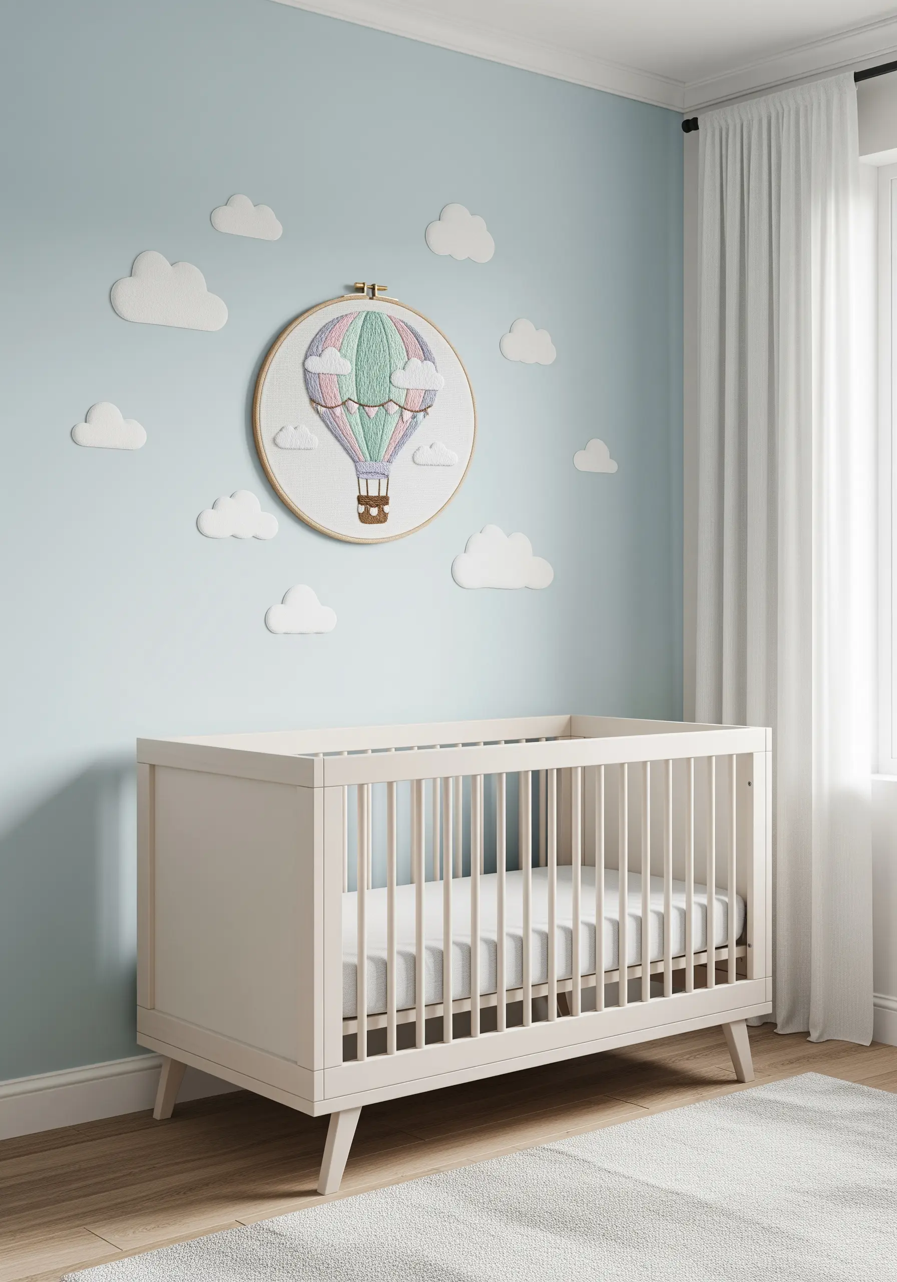 Embroidered hot air balloon with soft pastel colors in a baby's nursery.