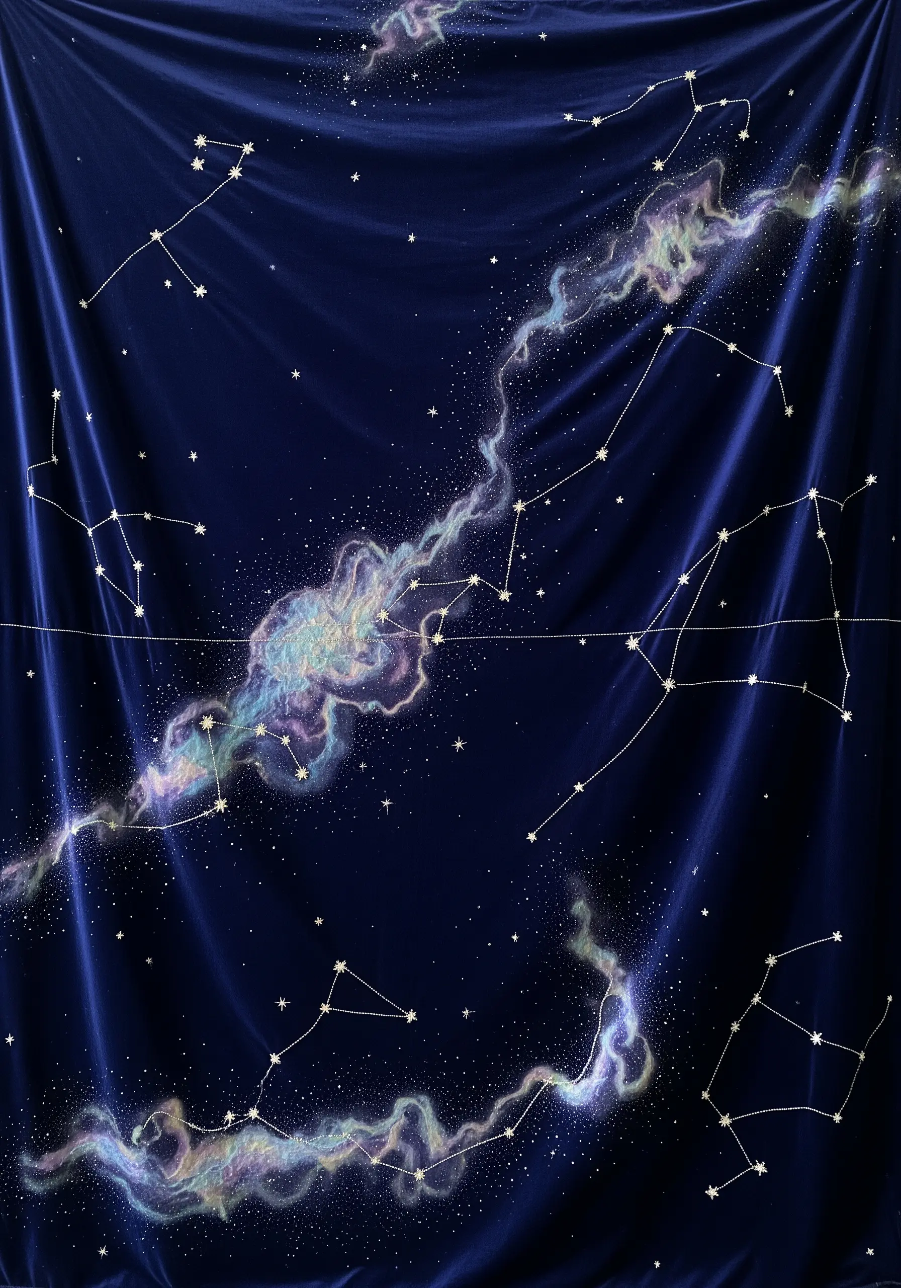 Constellations stitched in silver metallic thread on a deep blue velvet fabric with a nebula.