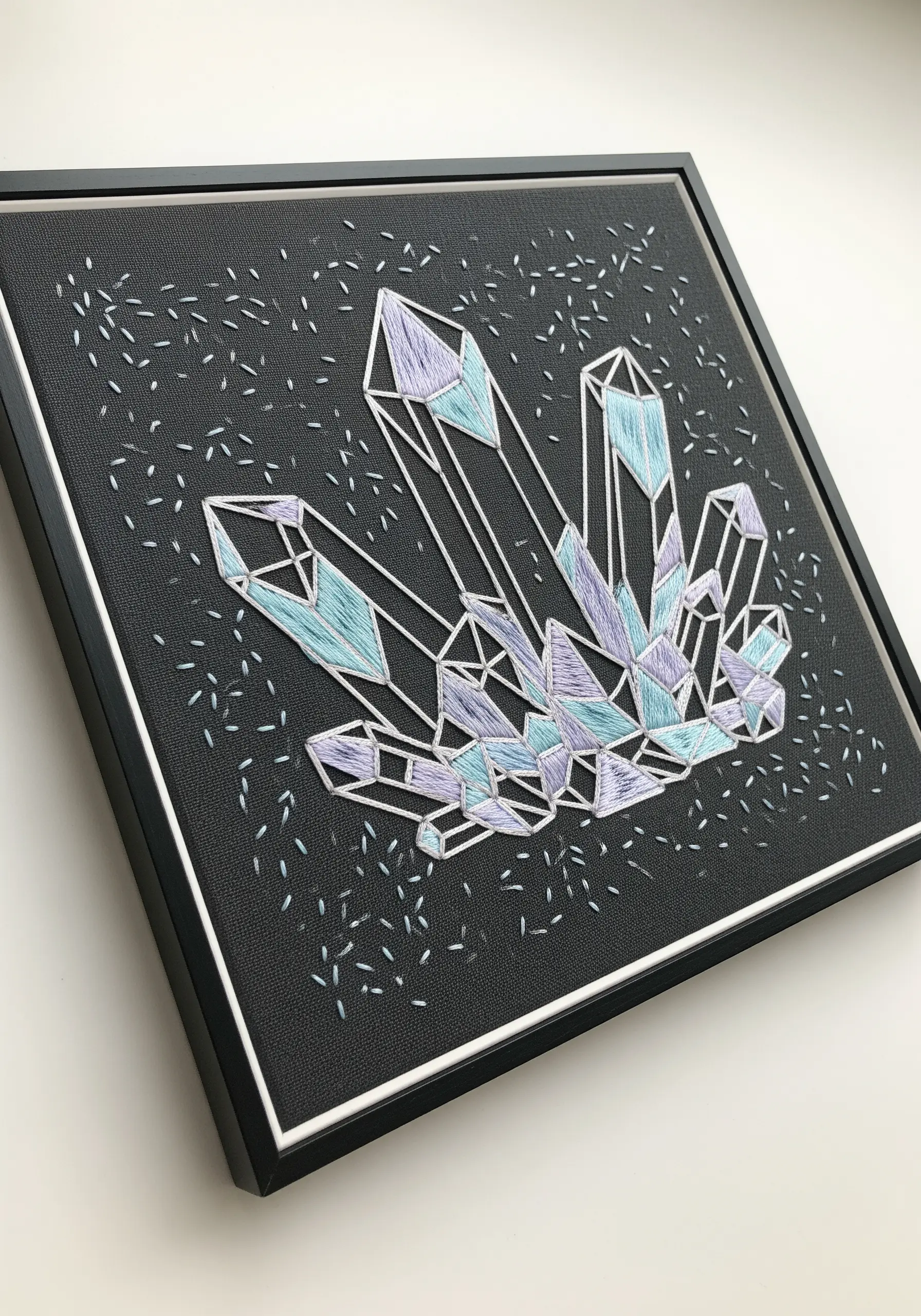 Framed geometric crystal embroidery using satin stitch in shades of blue and purple.