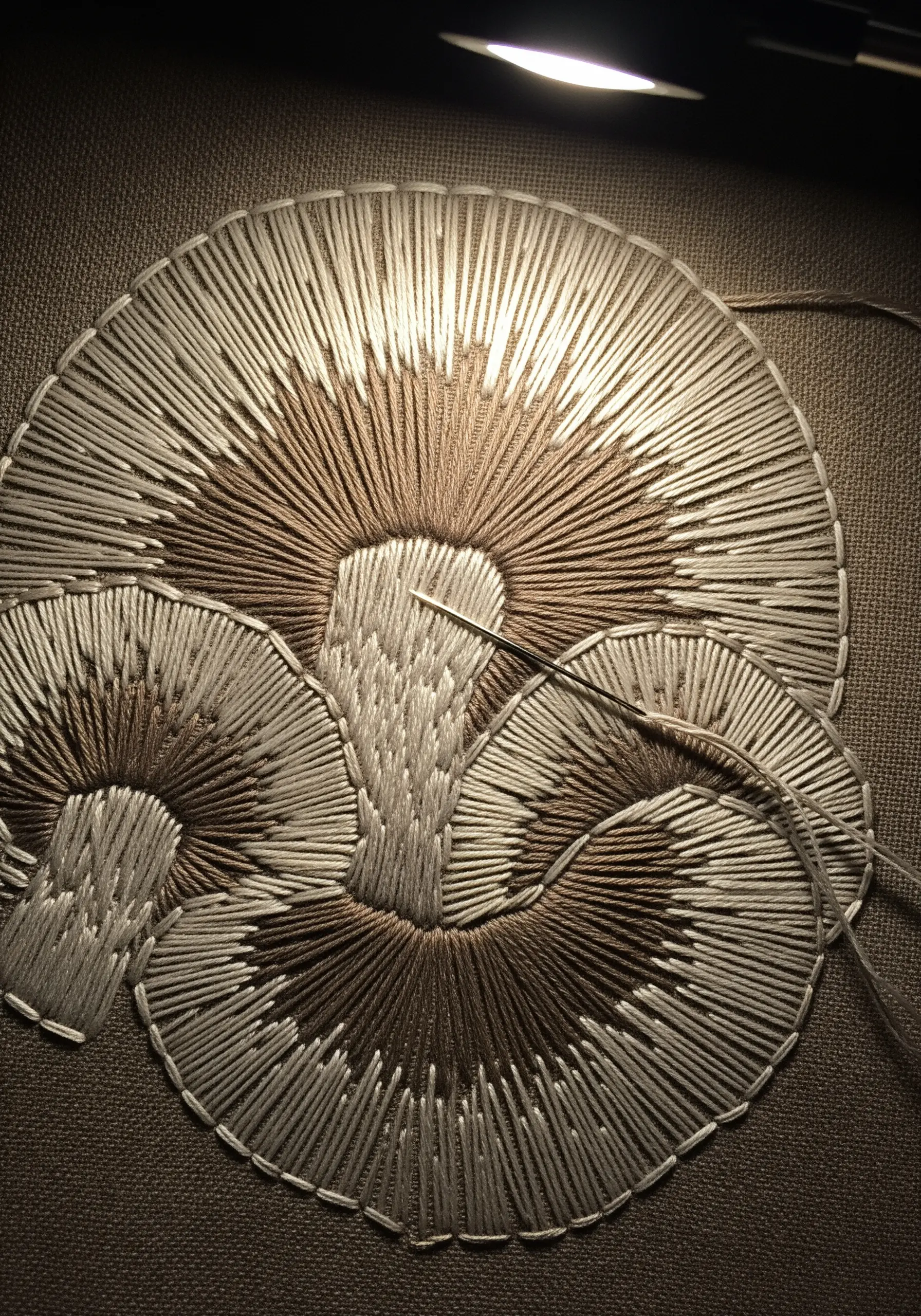 Embroidery in progress showing the radial stitches of mushroom gills.