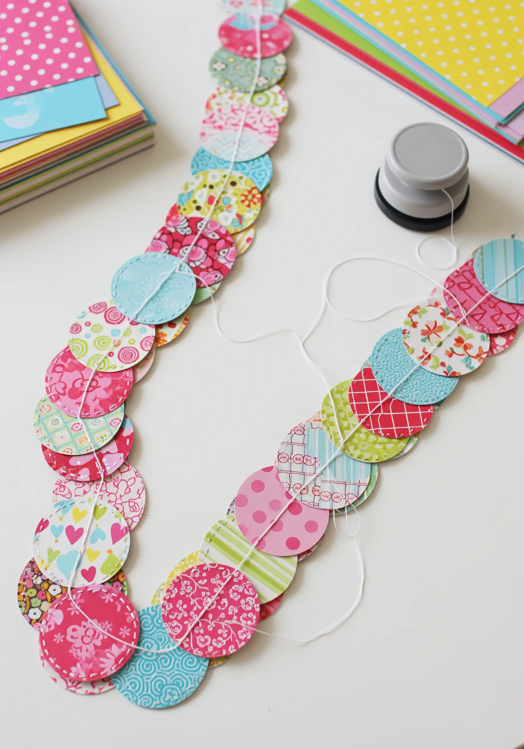 A colorful garland made from patterned paper circles stitched in a line.