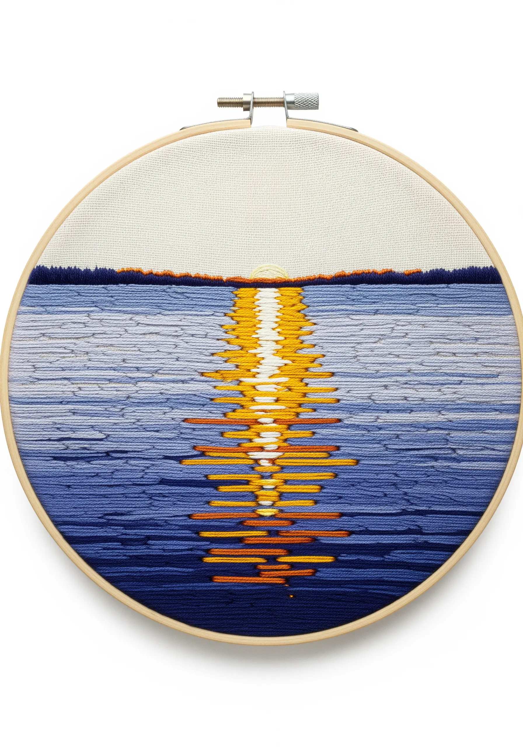 Embroidered lake sunset with a vibrant orange and yellow satin stitch reflection.
