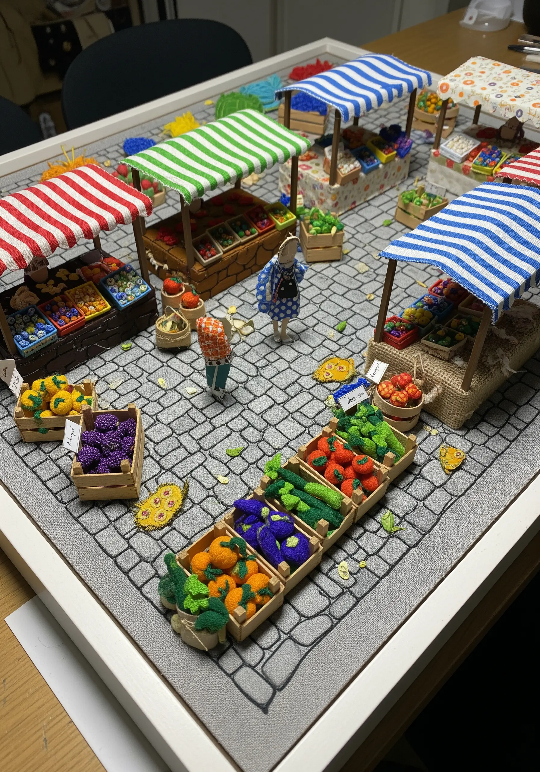 A miniature 3D scene of a farmers market with tiny embroidered fruits and vegetables