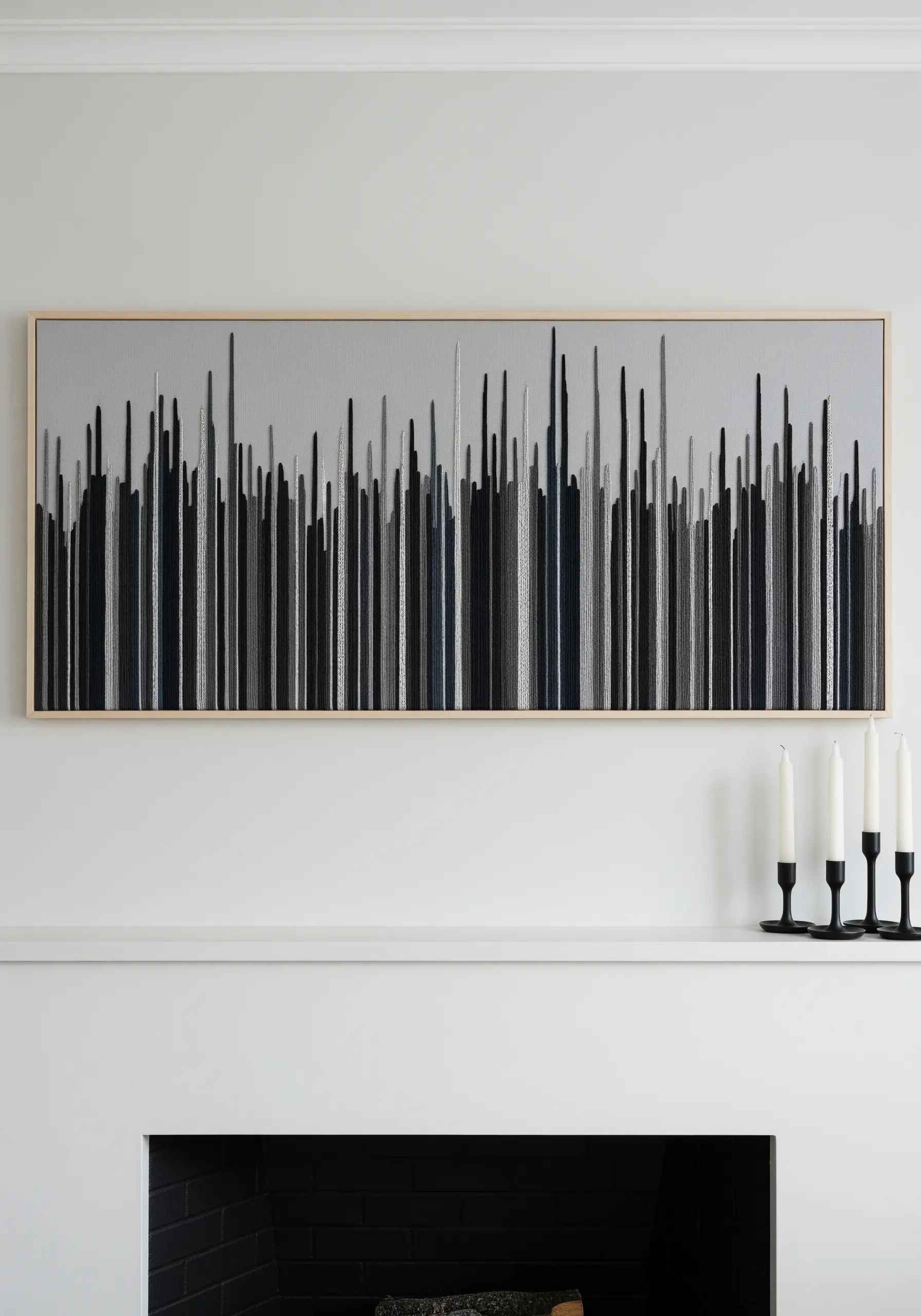 A long framed embroidery of an abstract skyline with vertical stitches in black and grey.