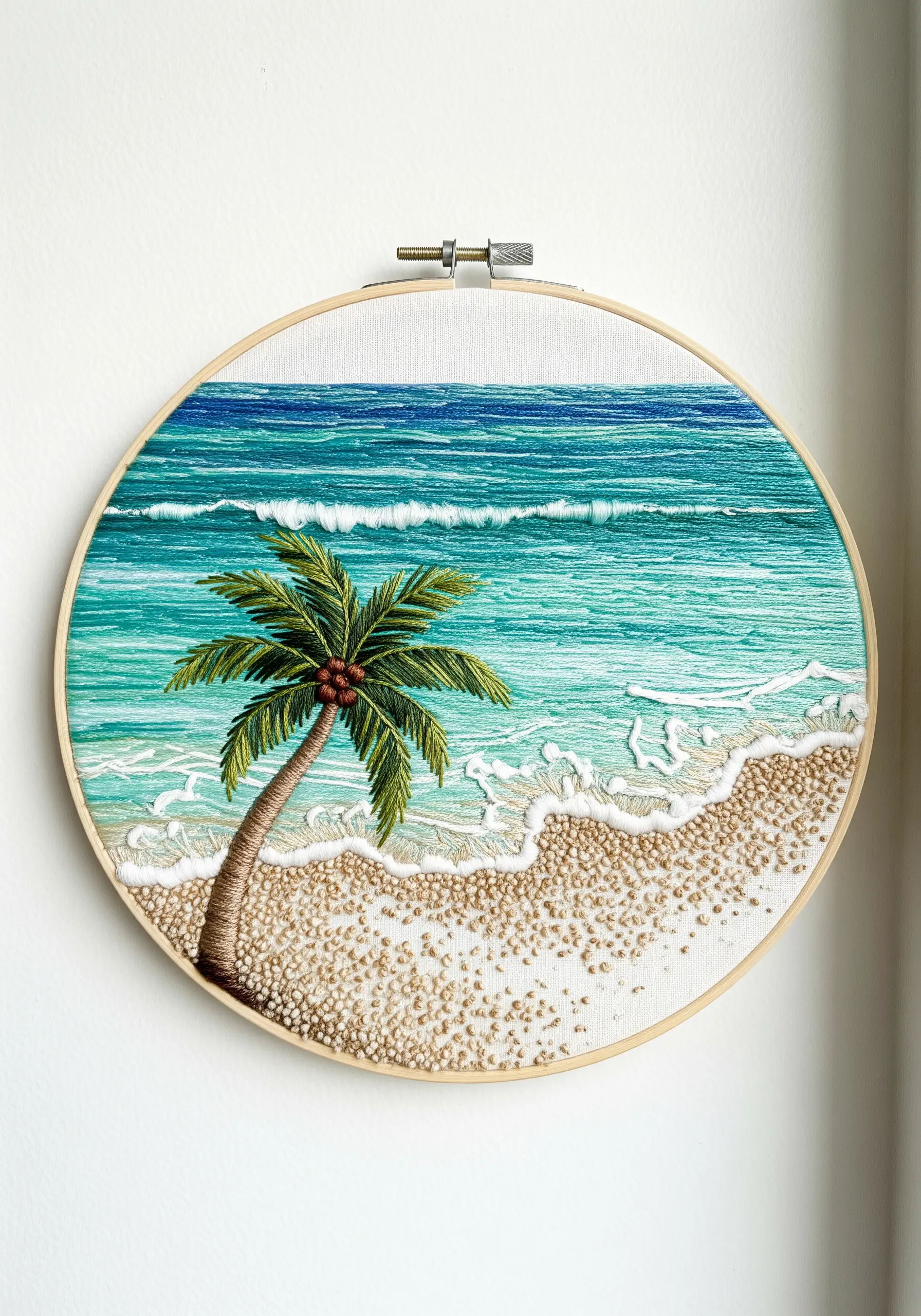 Embroidery of a tropical beach with a palm tree, textured sand, and frothy seafoam.