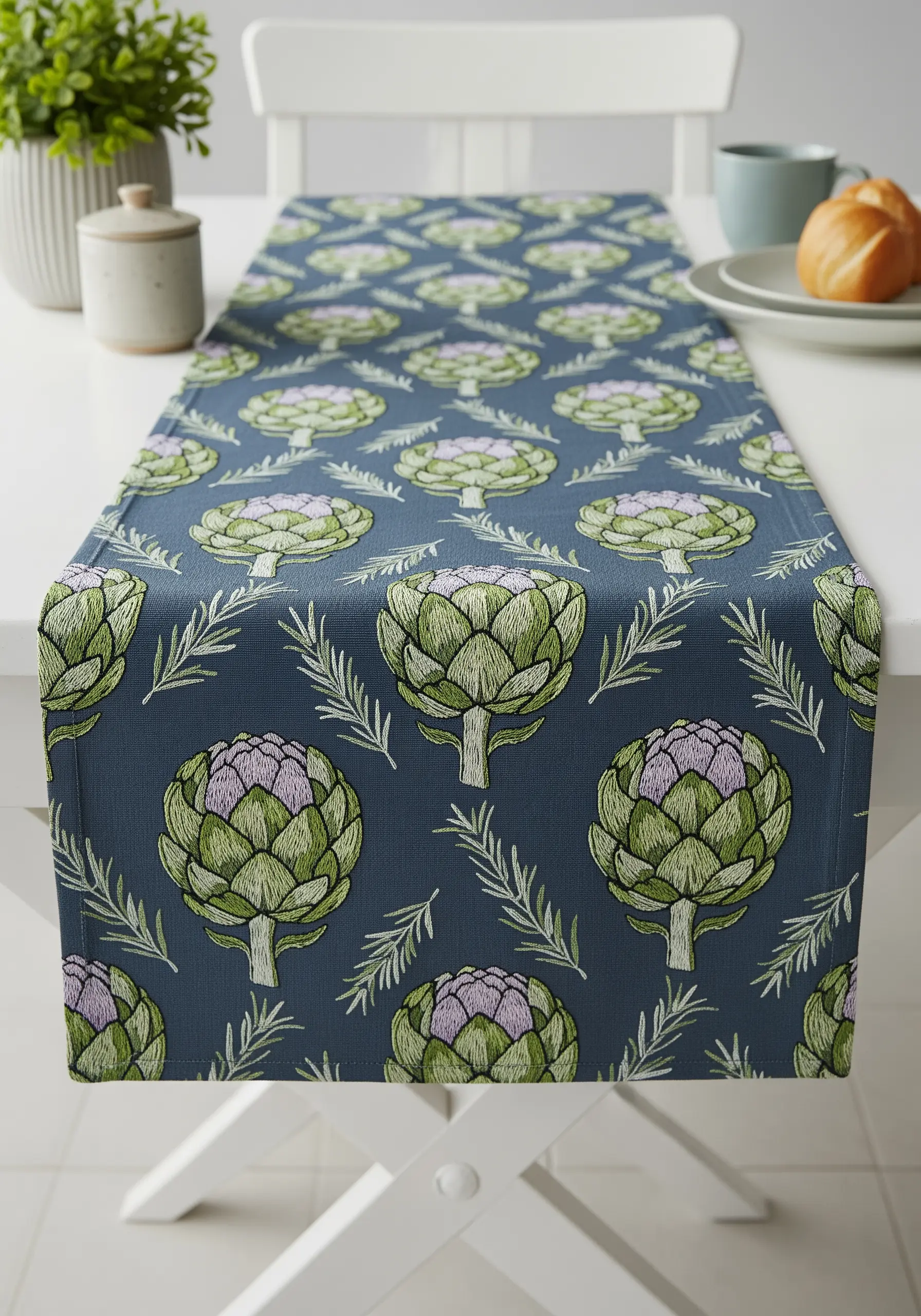 A table runner with a repeating pattern of embroidered artichokes and rosemary sprigs.