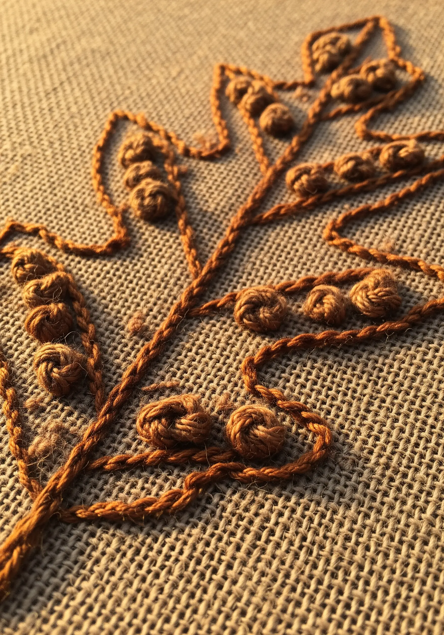 Oak leaf outline on burlap with bullion knots stitched along the veins.