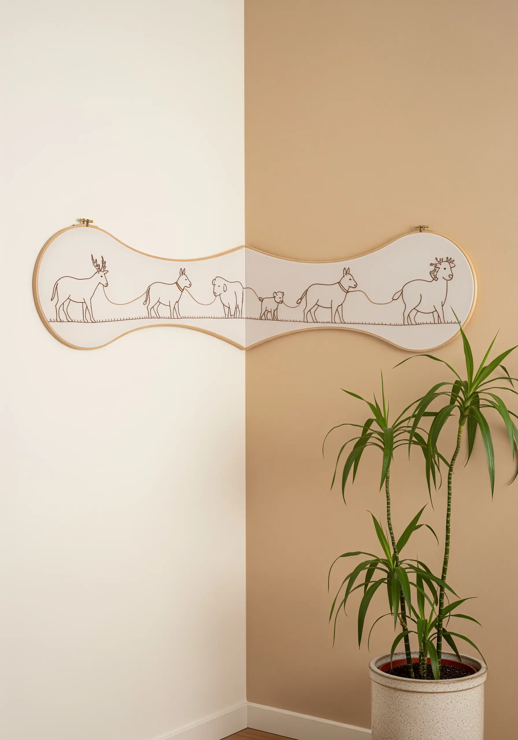 A long, custom-shaped embroidery frame with a continuous line of stitched animals