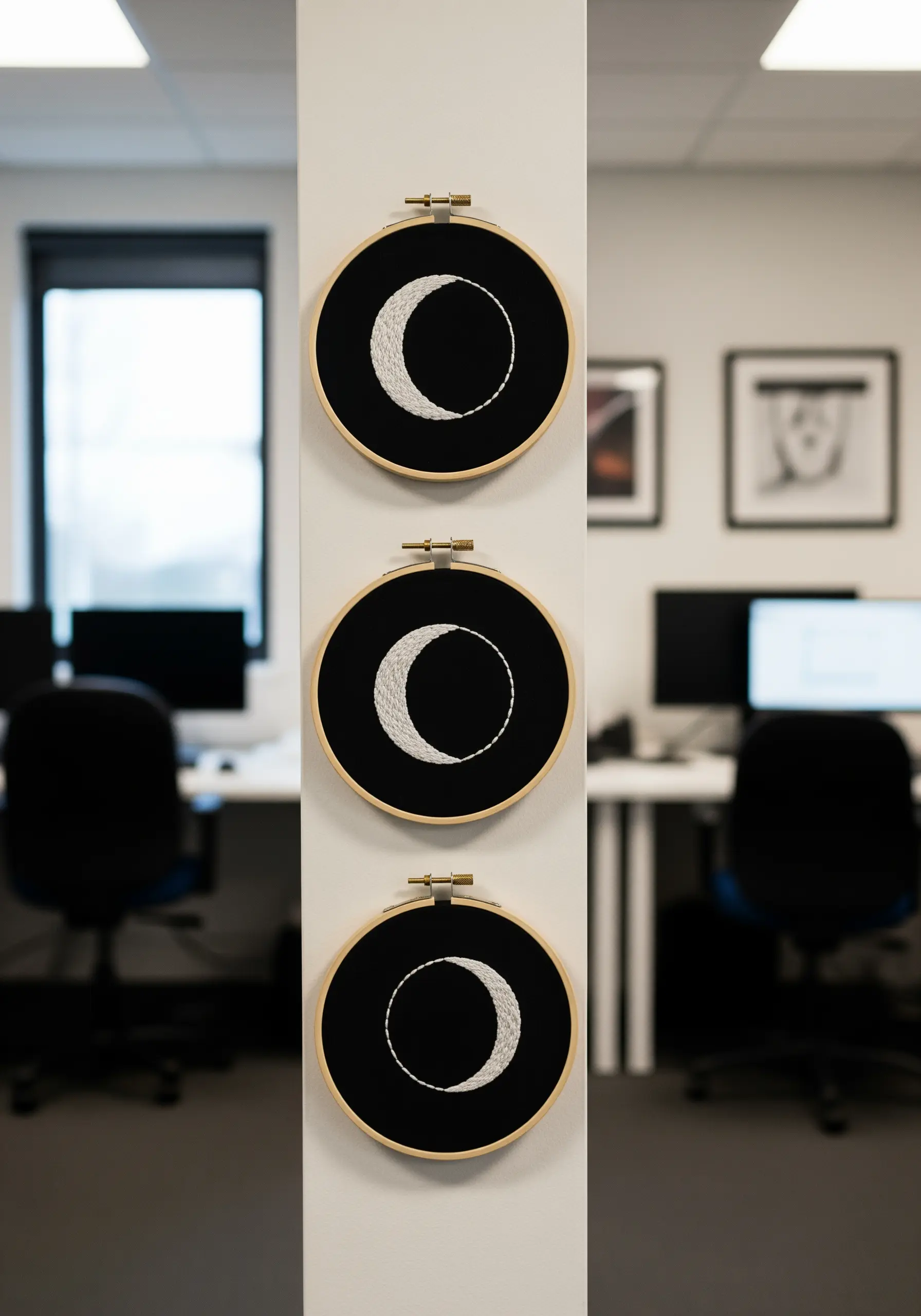 A vertical series of three embroidery hoops showing different phases of the moon.
