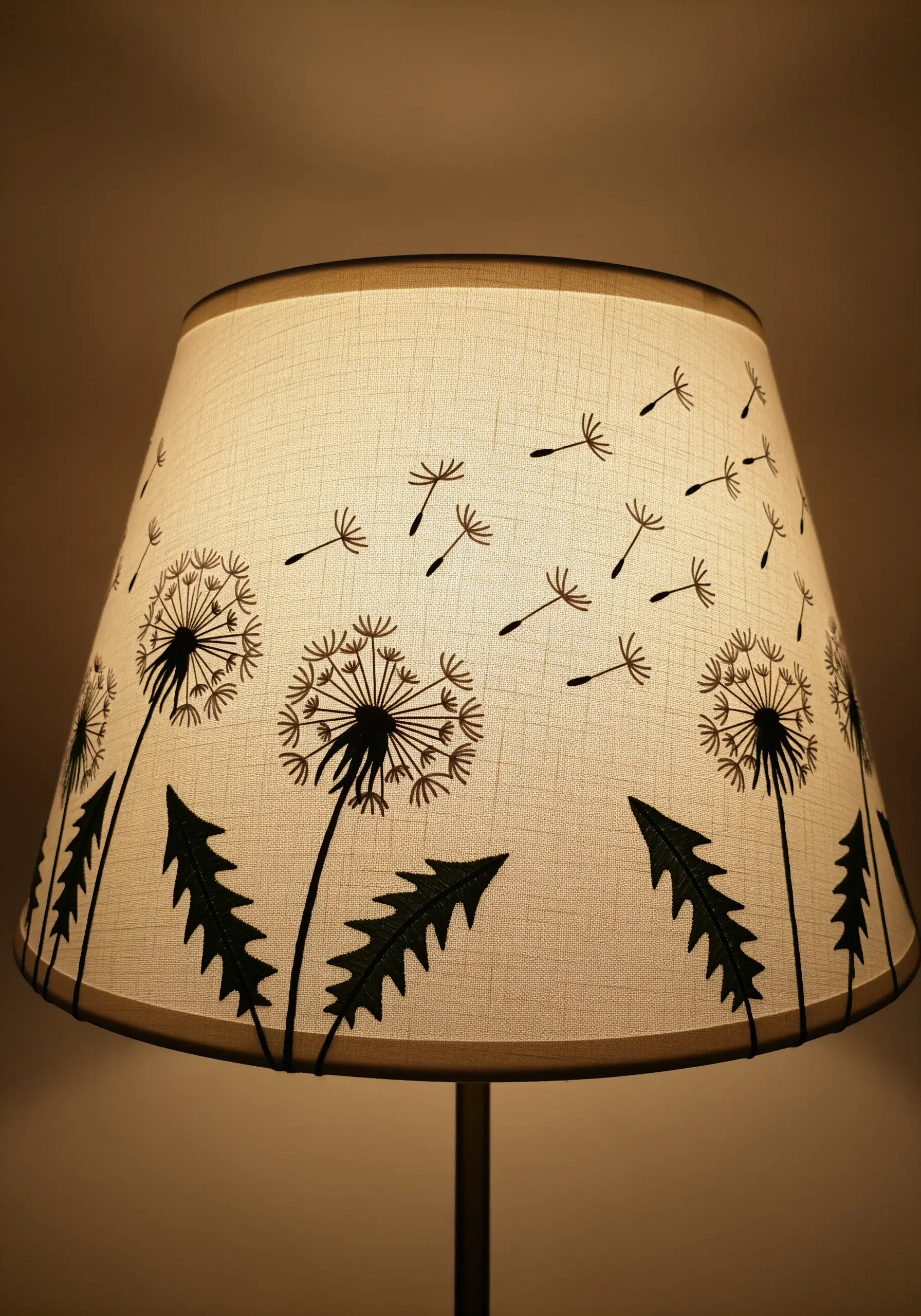 Minimalist black-thread dandelions with seeds blowing in the wind on a linen lampshade.