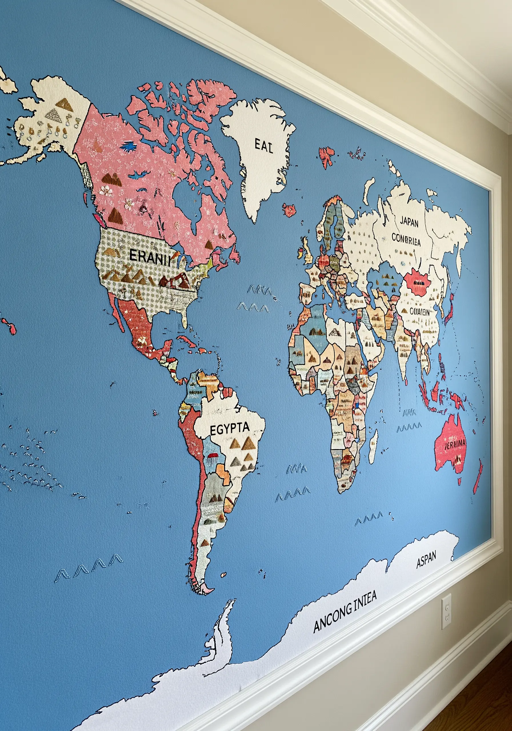 Large world map made from colorful fabric appliqué with embroidered country names.