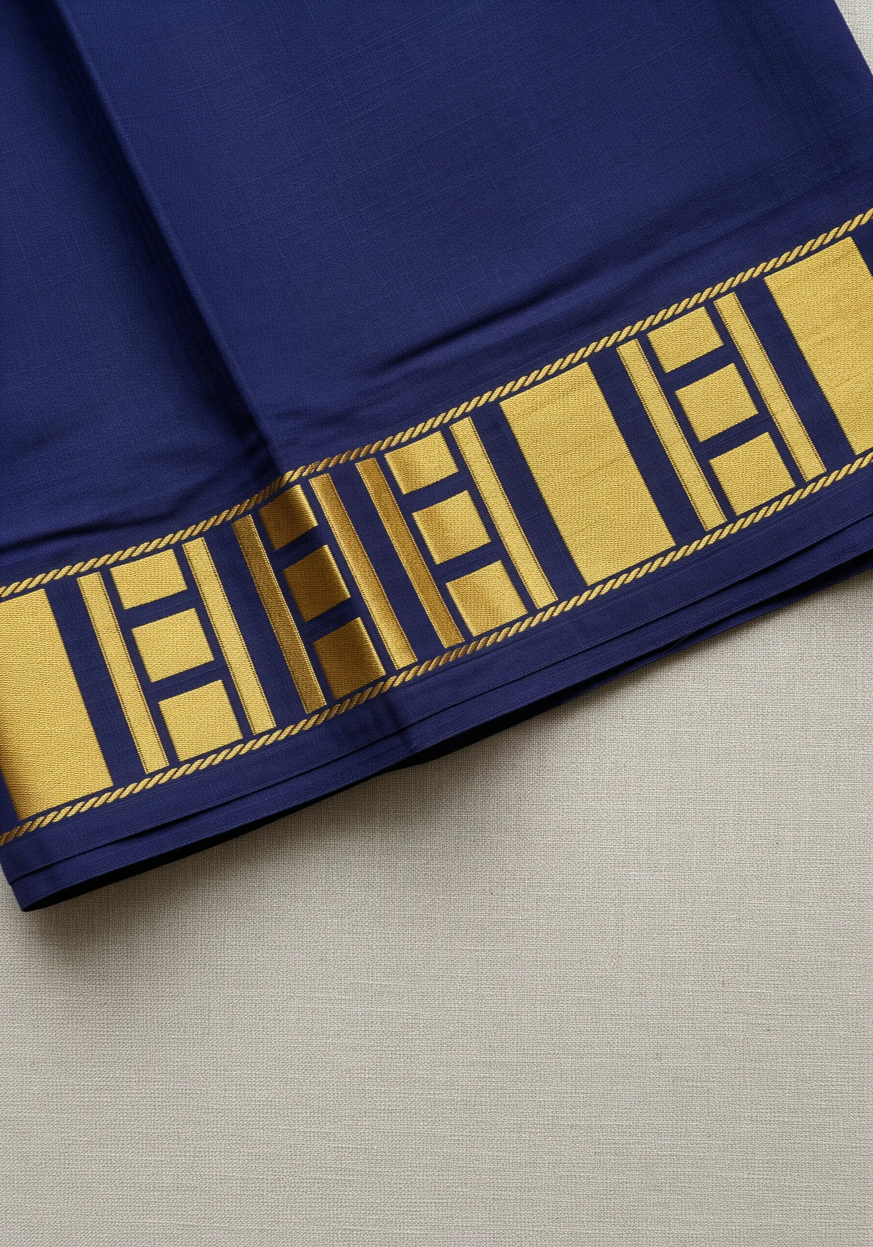 Bold gold satin stitch geometric border on a royal blue saree.