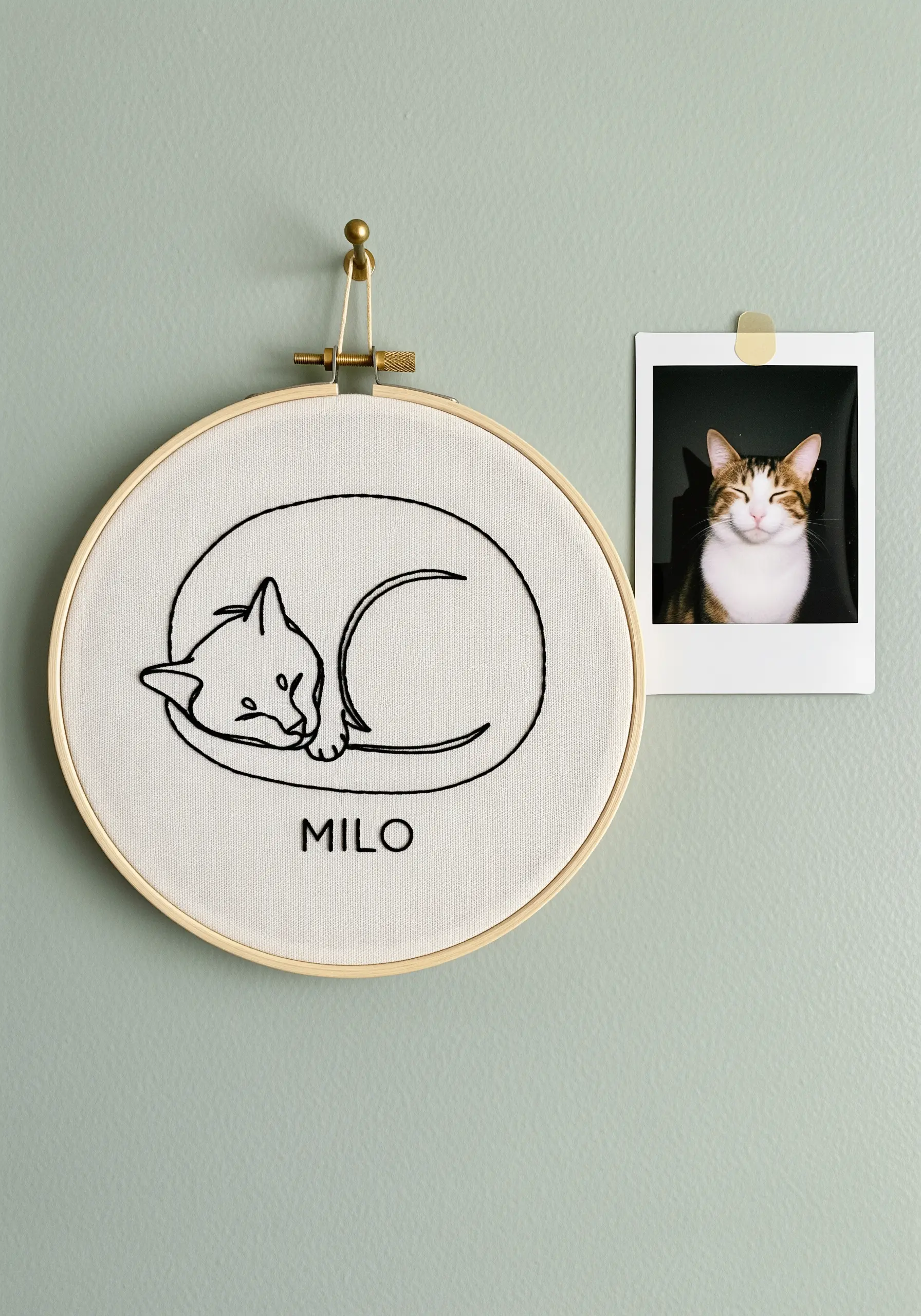 Minimalist line art of a sleeping cat in a wooden embroidery hoop.