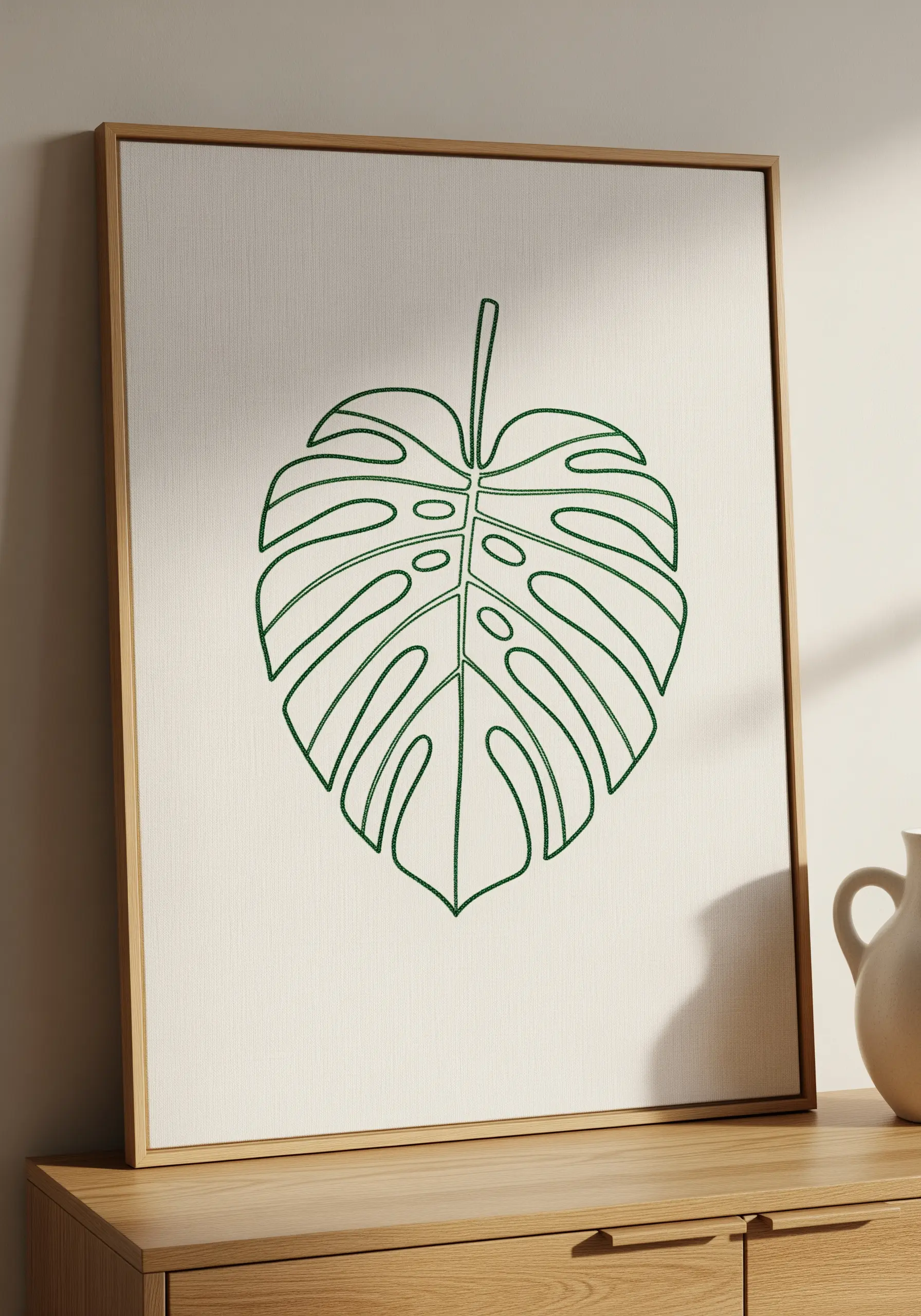 Minimalist line art embroidery of a Monstera leaf in green thread.