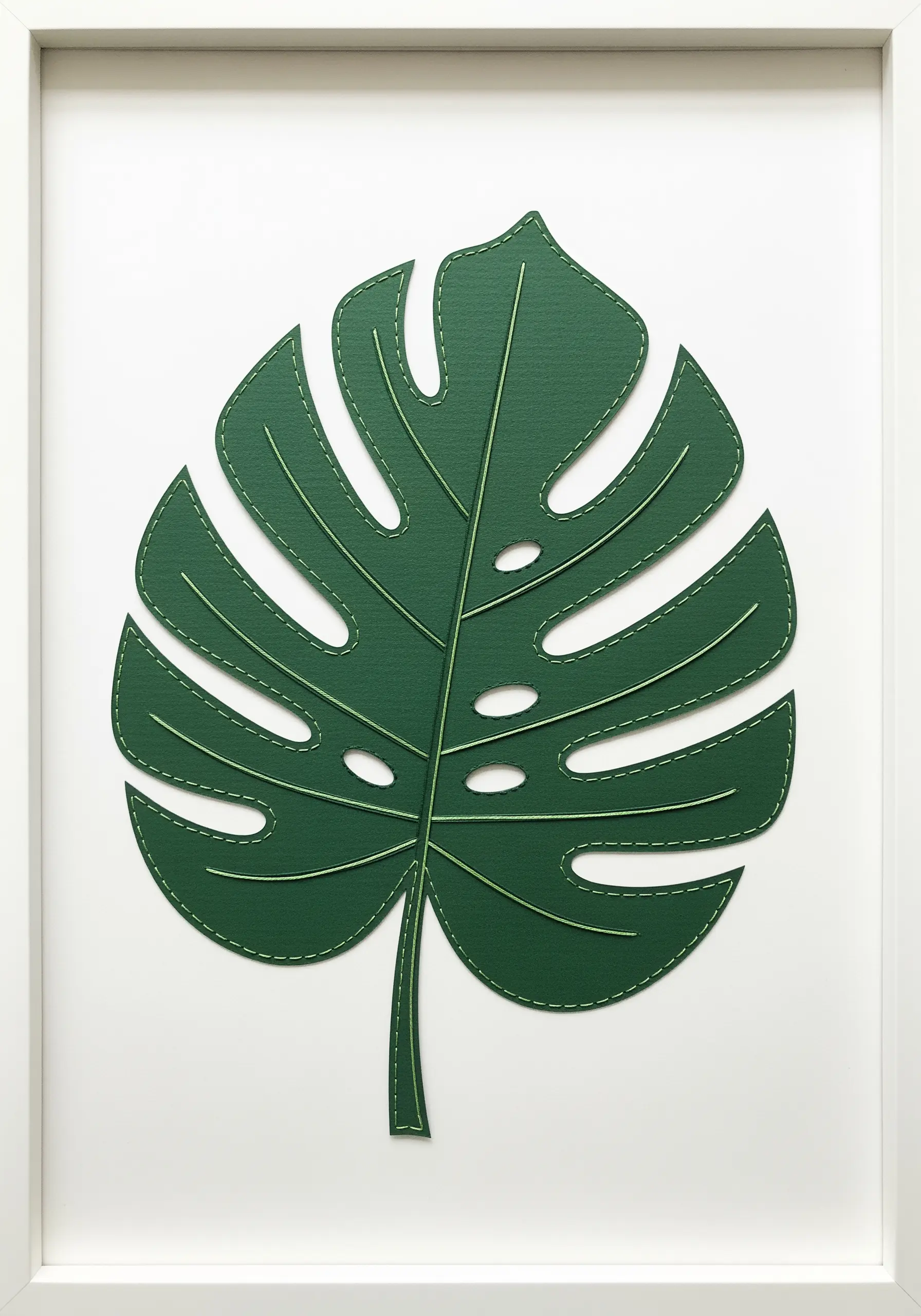 A green paper cutout of a monstera leaf with veins detailed in a simple running stitch.