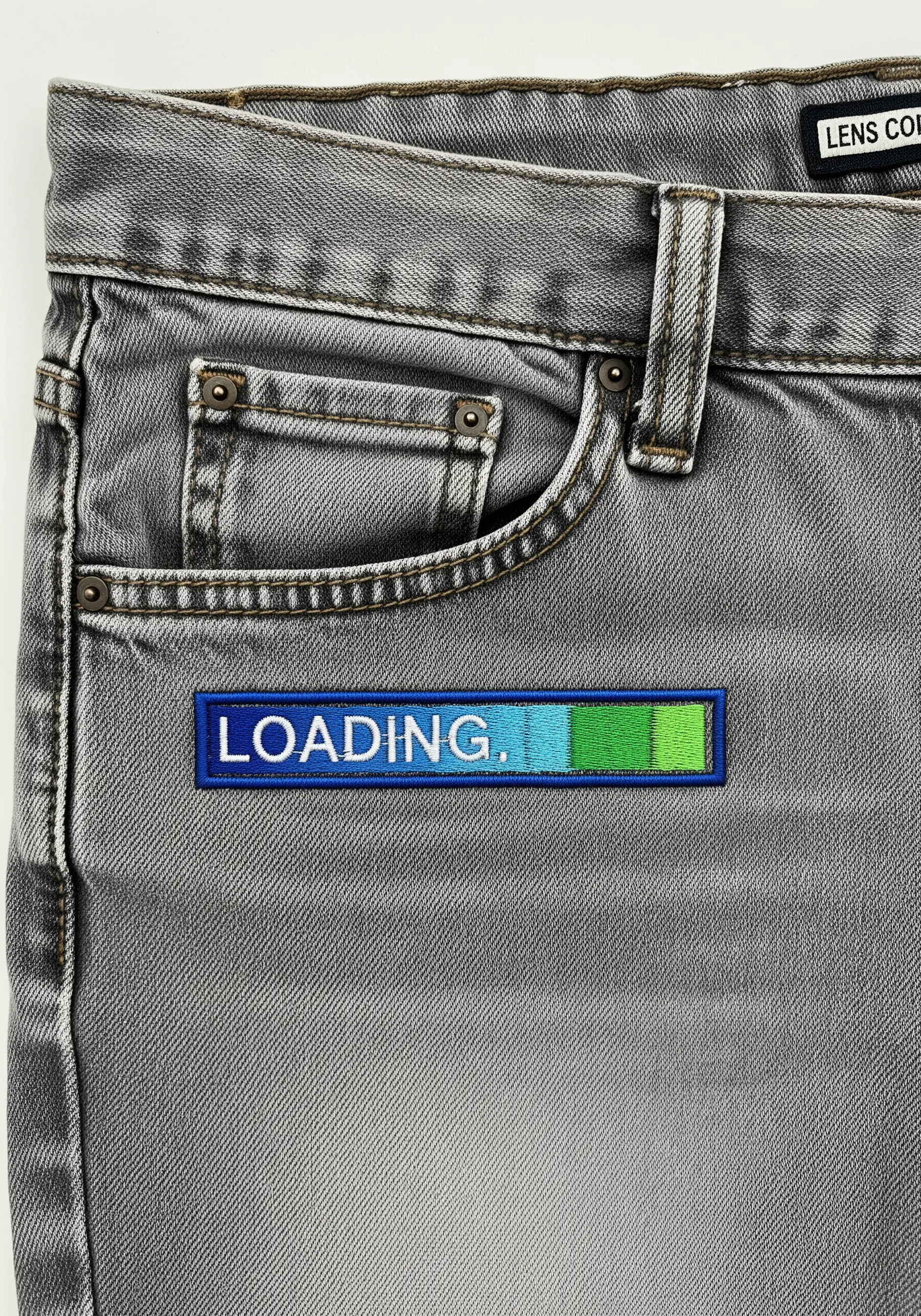 An embroidered loading bar with a blue-to-green gradient on gray jeans.