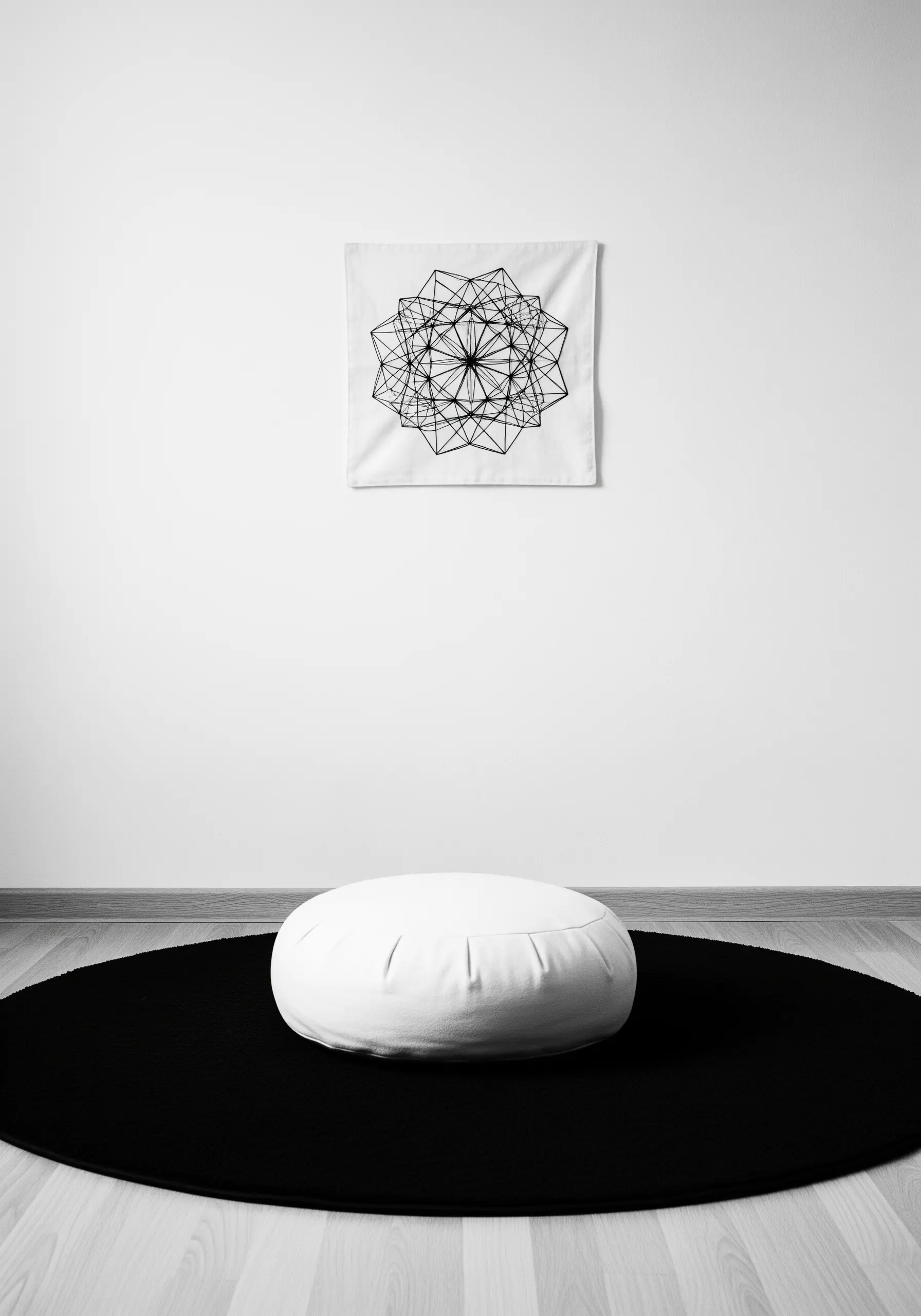 A black thread geometric mandala on a white fabric square.