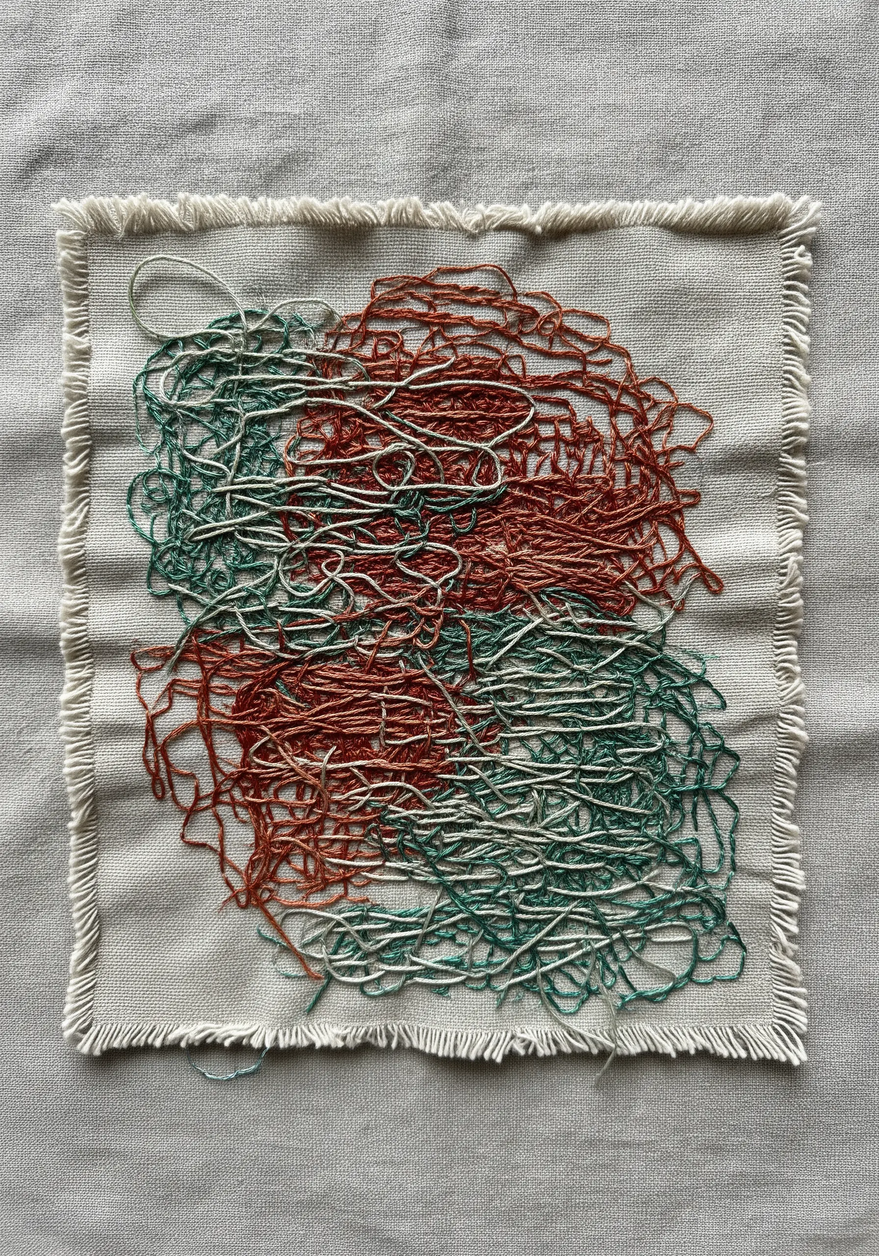 Abstract scribble embroidery with layered red, green, and white threads on frayed fabric.