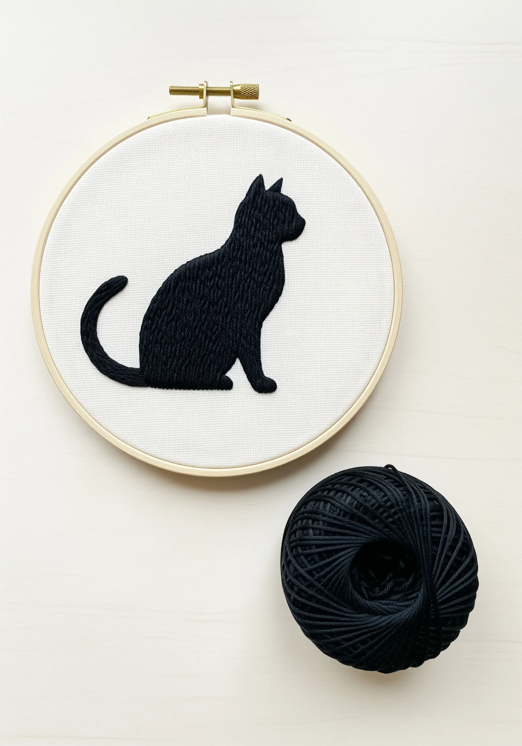 A solid black cat silhouette filled with a dense, smooth embroidery stitch.