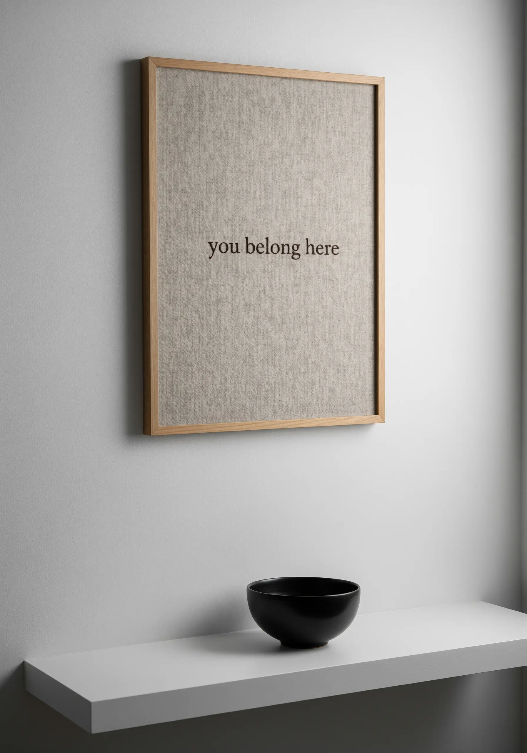 Minimalist 'you belong here' embroidered in a simple font on beige linen.