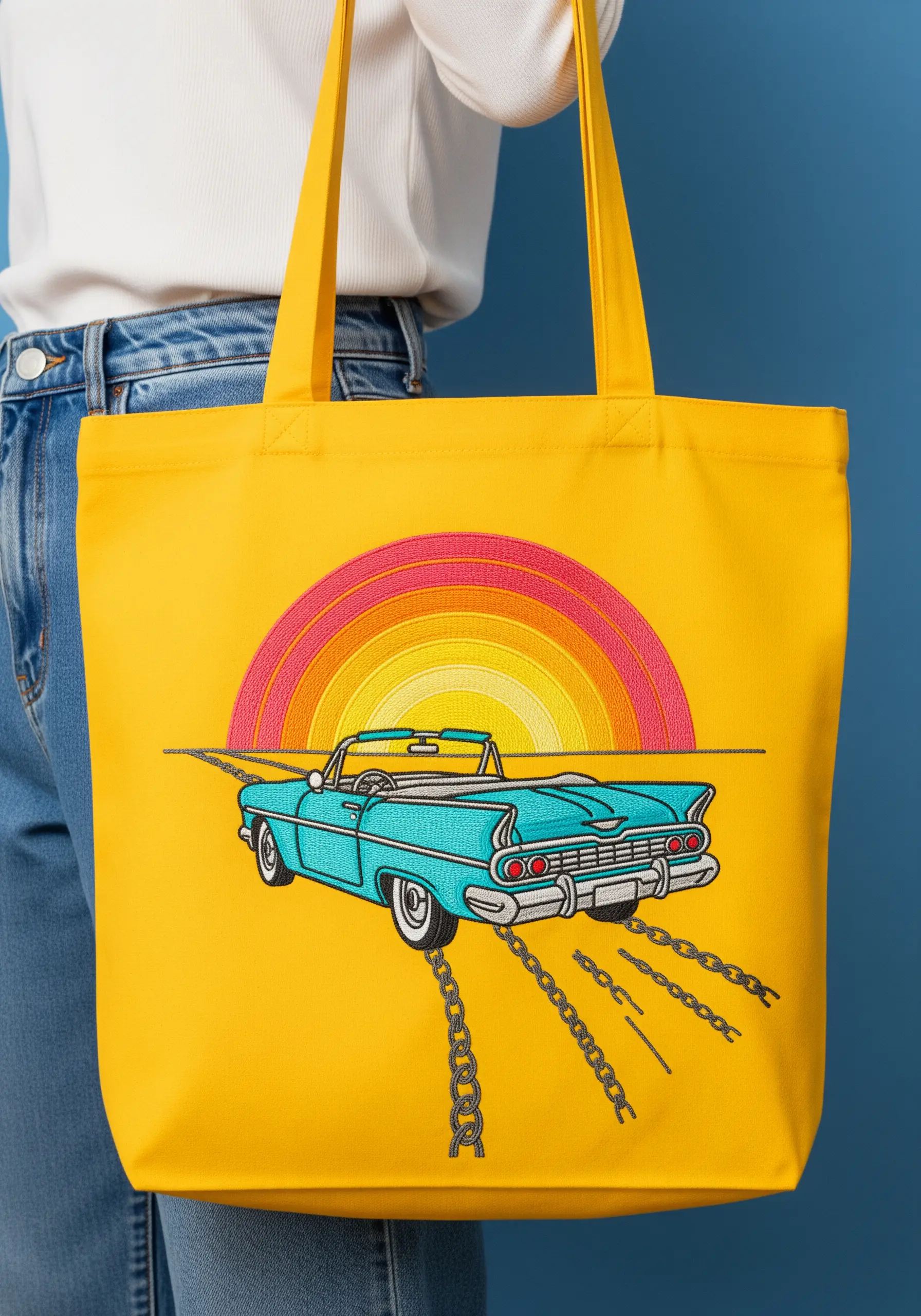 A retro convertible and sunset embroidered in a graphic style on a yellow tote bag.