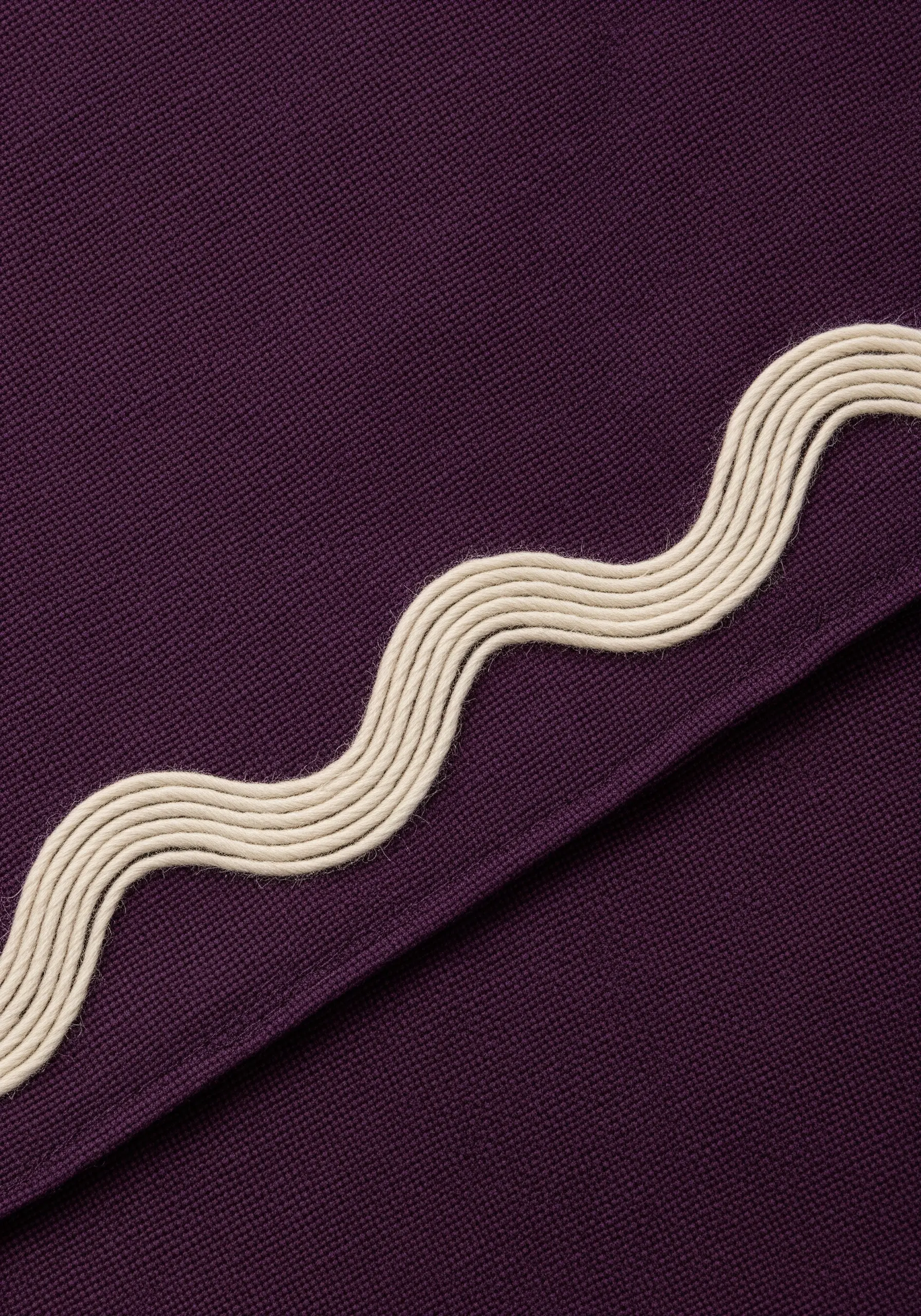 Parallel wavy lines in cream thread on a dark purple fabric.