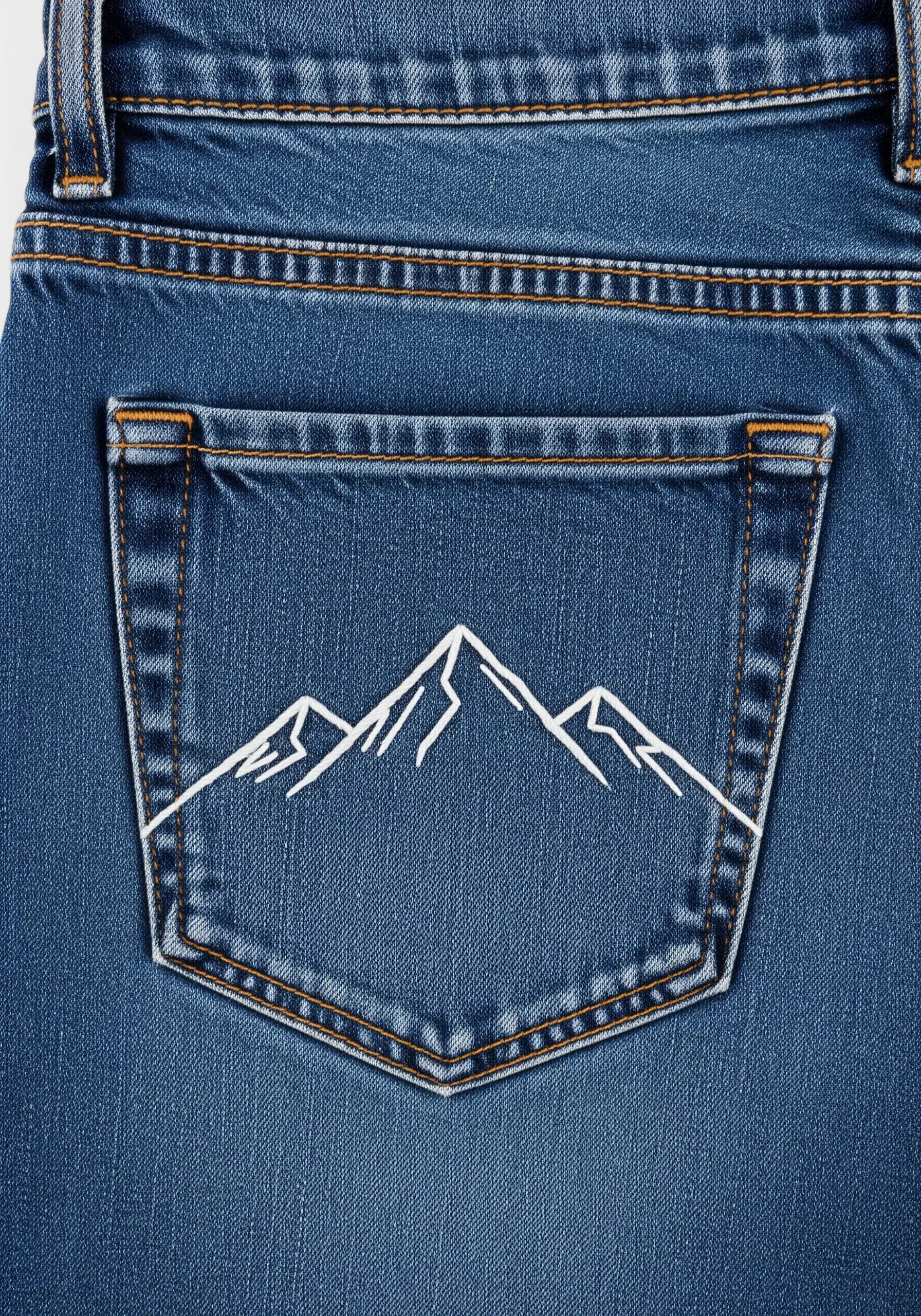 Minimalist mountain range outline stitched in white thread on a blue jean pocket.