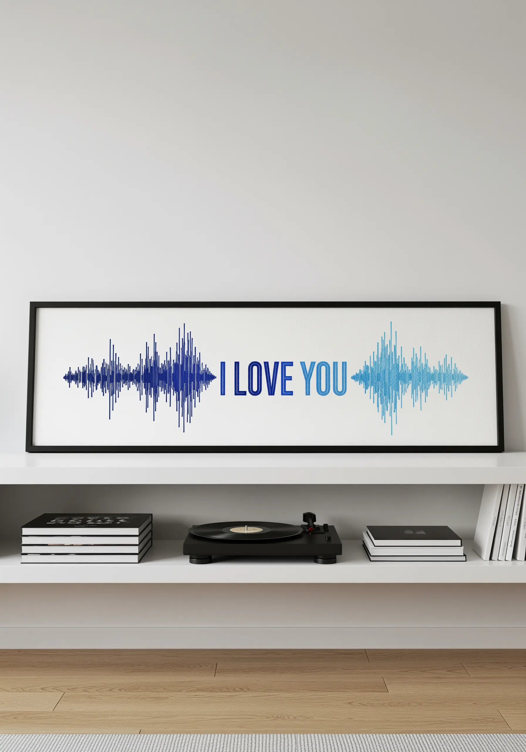 An embroidered soundwave of 'I love you' in shades of blue, displayed in a long frame.