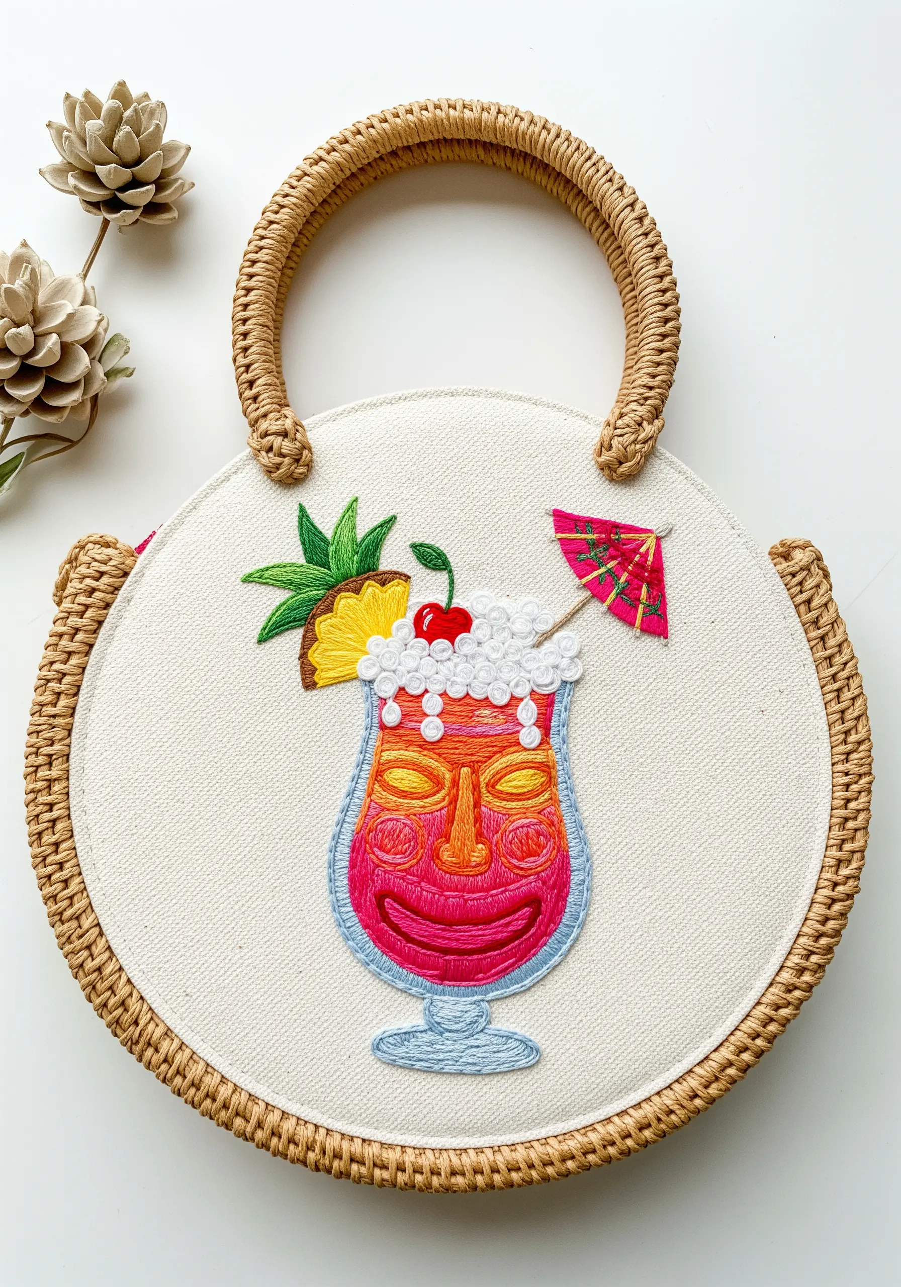 A colorful embroidered tiki cocktail with textured stitches for foam and fruit.
