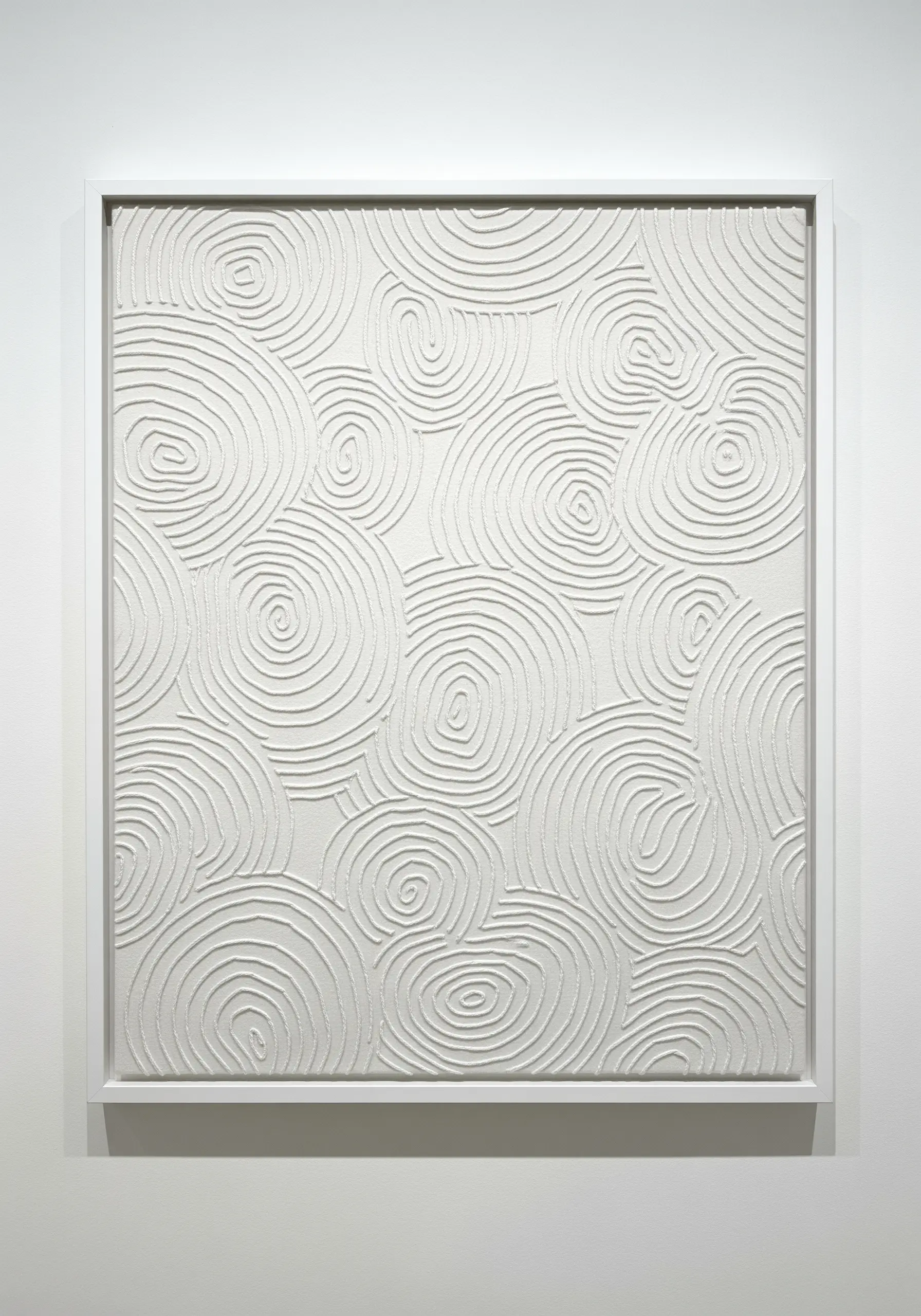 A white canvas filled with dense, tone-on-tone white embroidery in swirling spiral patterns.