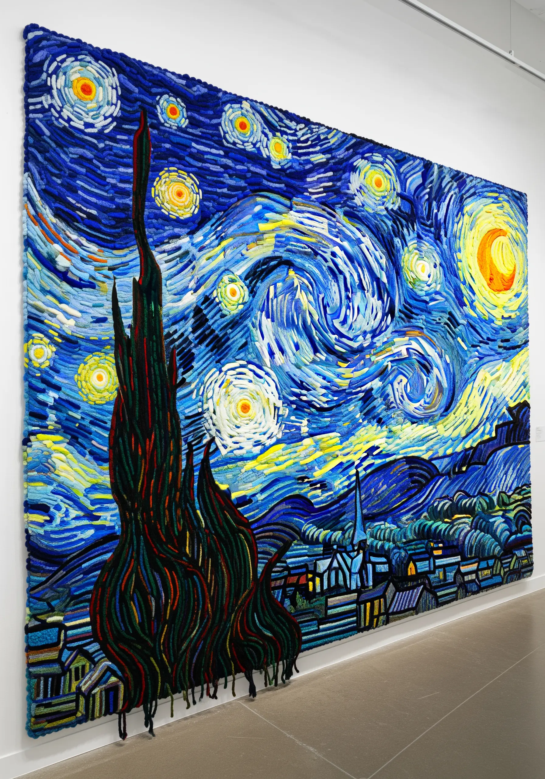 Large-scale fiber art of Van Gogh's Starry Night with thick, swirling yarn textures.