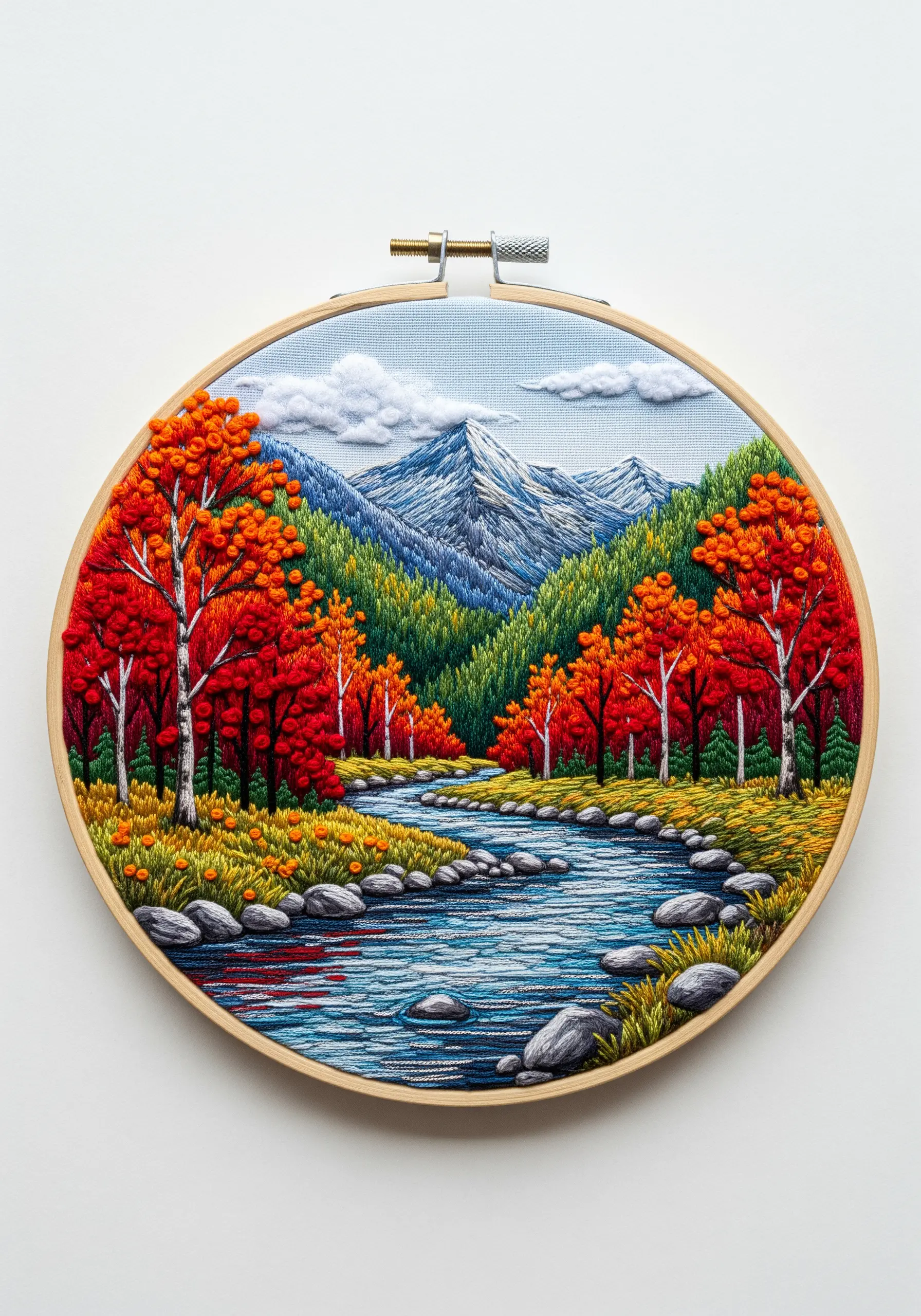 Embroidery of an autumn river scene with bright red trees and a contrasting blue stream.