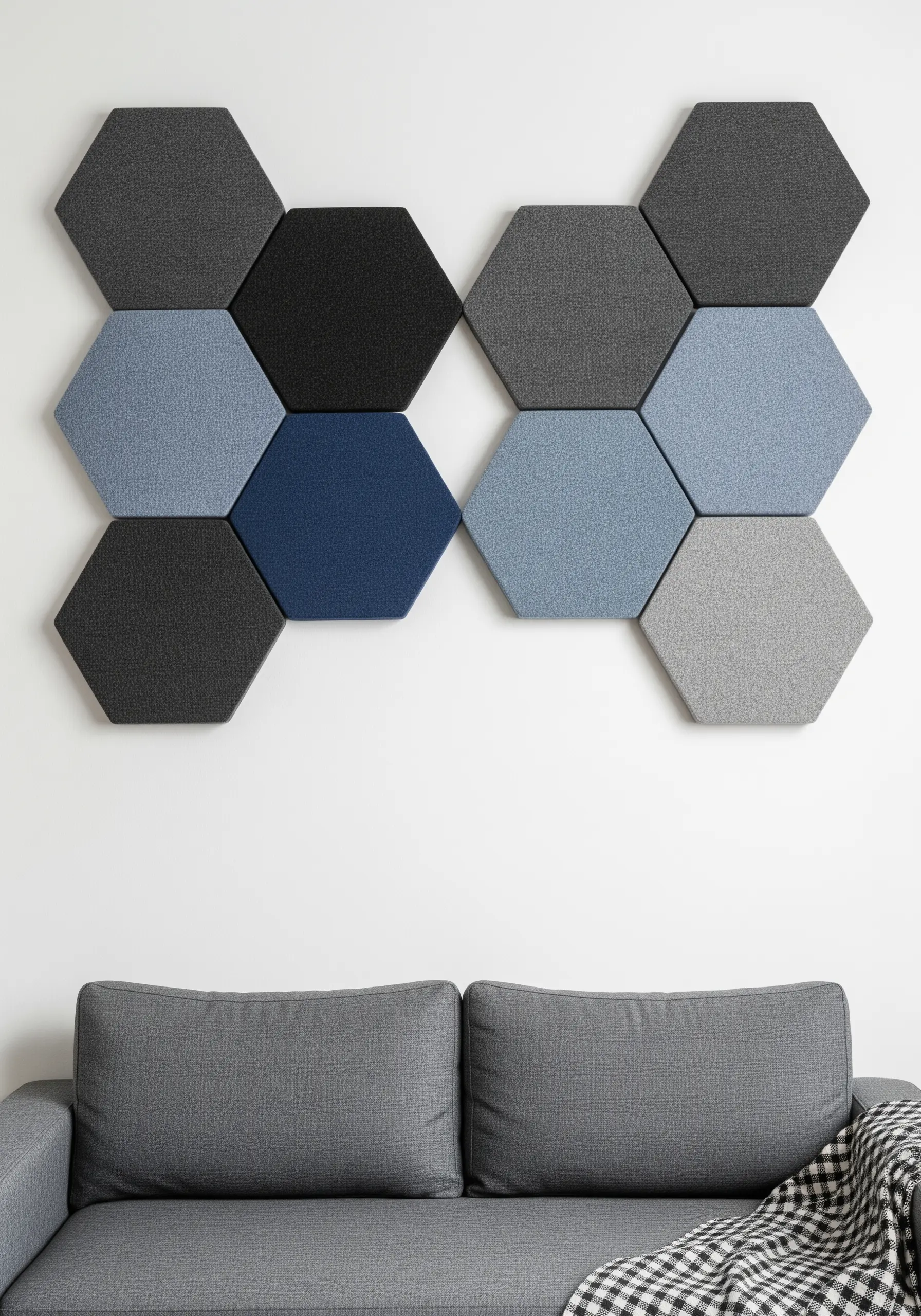 Geometric wall art made of hexagonal fabric-covered panels in grey and blue.