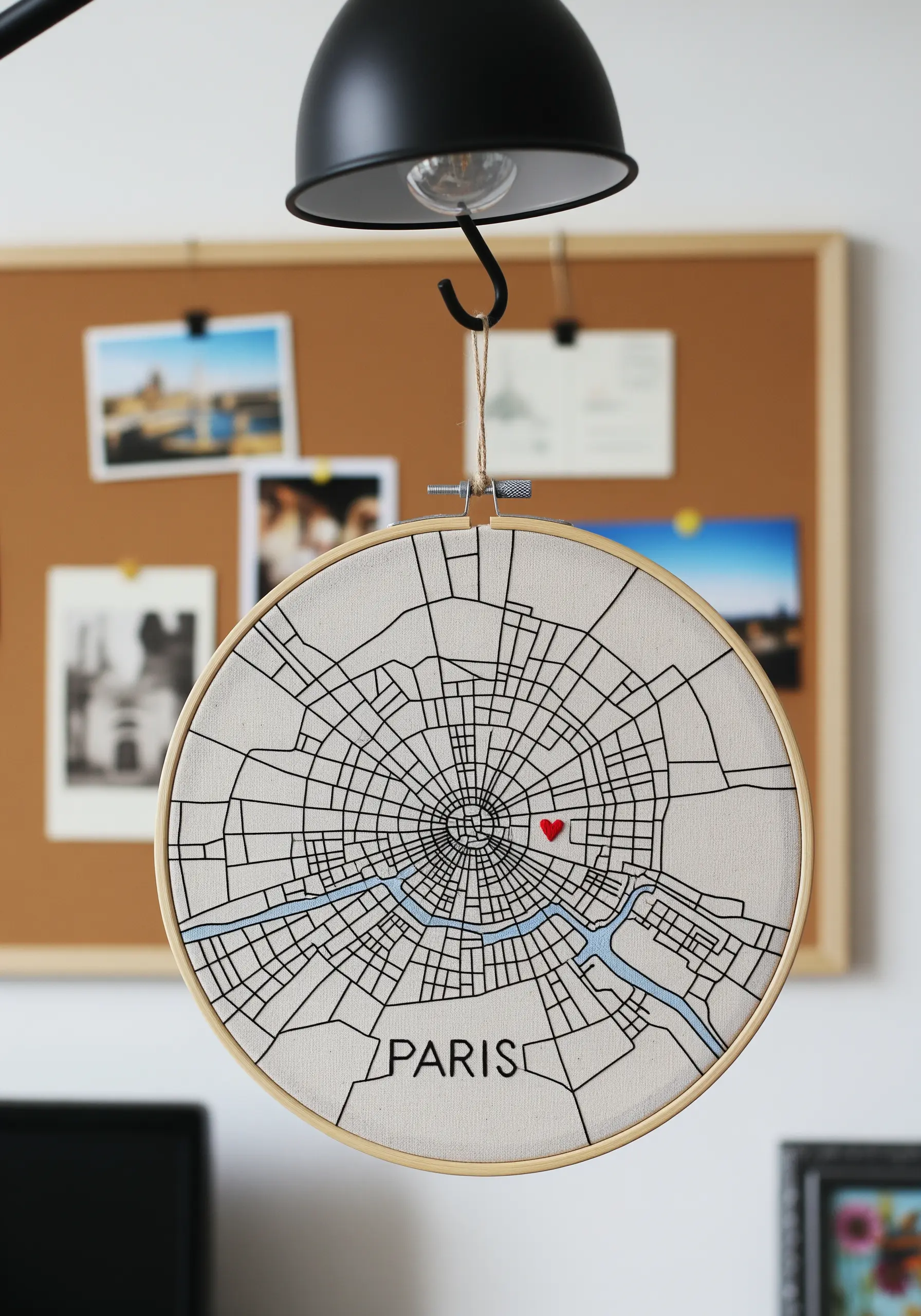 A minimalist embroidered map of Paris in black thread, with a single red heart.