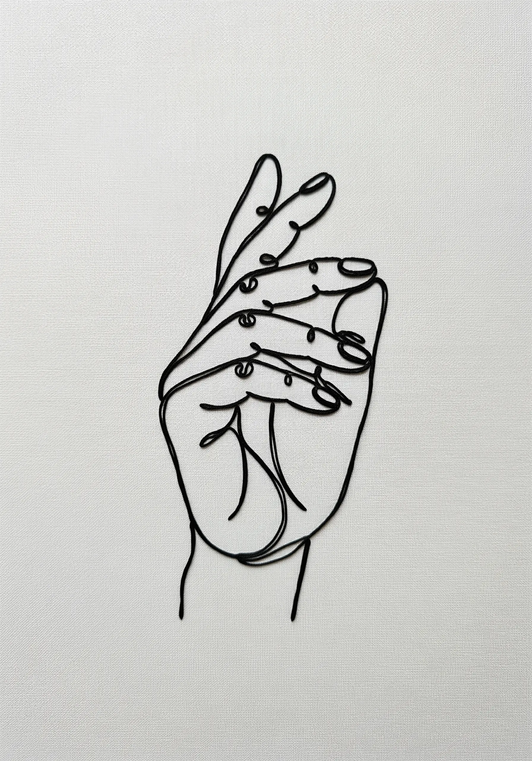 A single-line art embroidery of a hand in the 'OK' gesture, stitched in black.