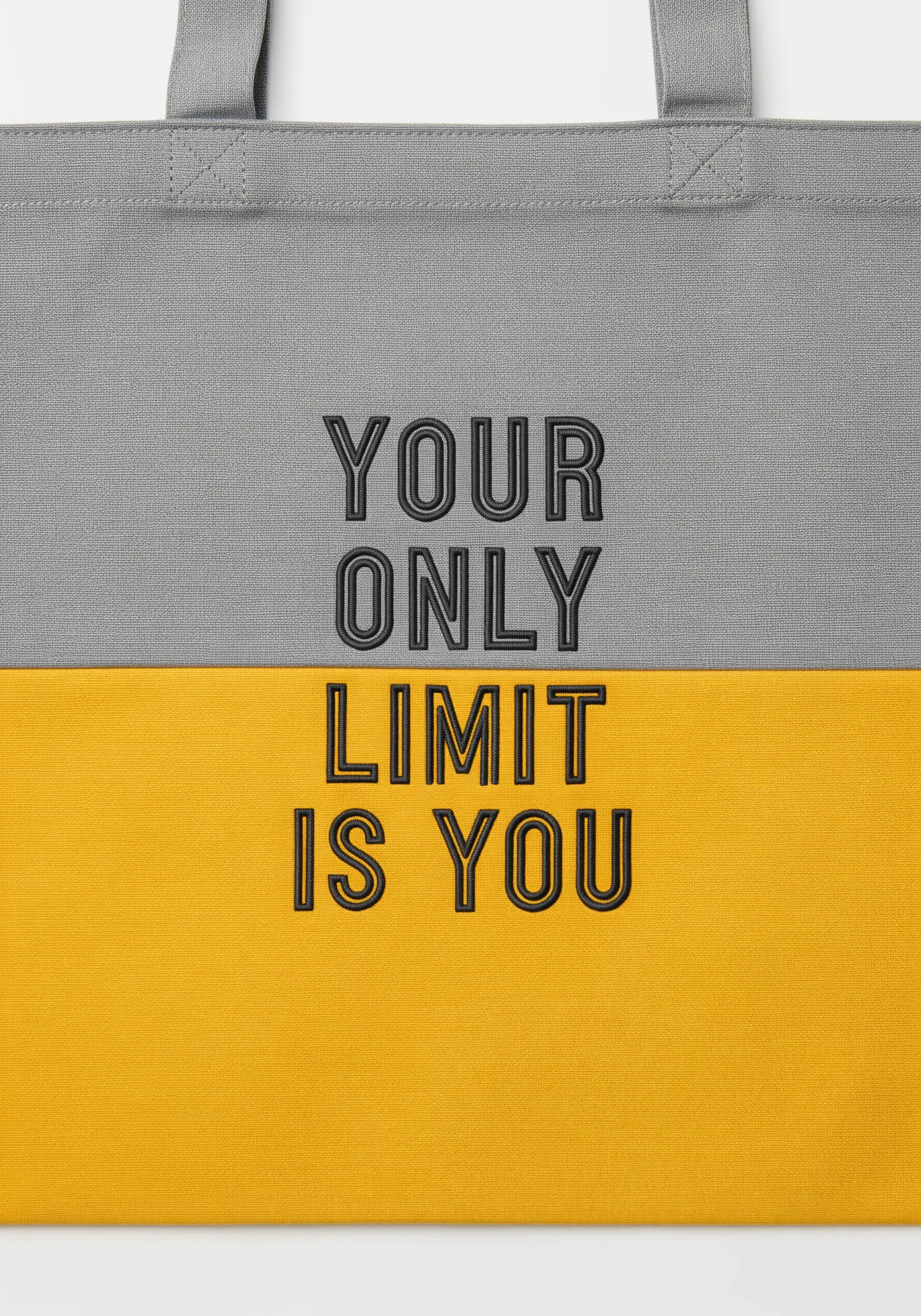 Embroidered quote on a color-blocked tote bag, with grey on top and yellow on the bottom.