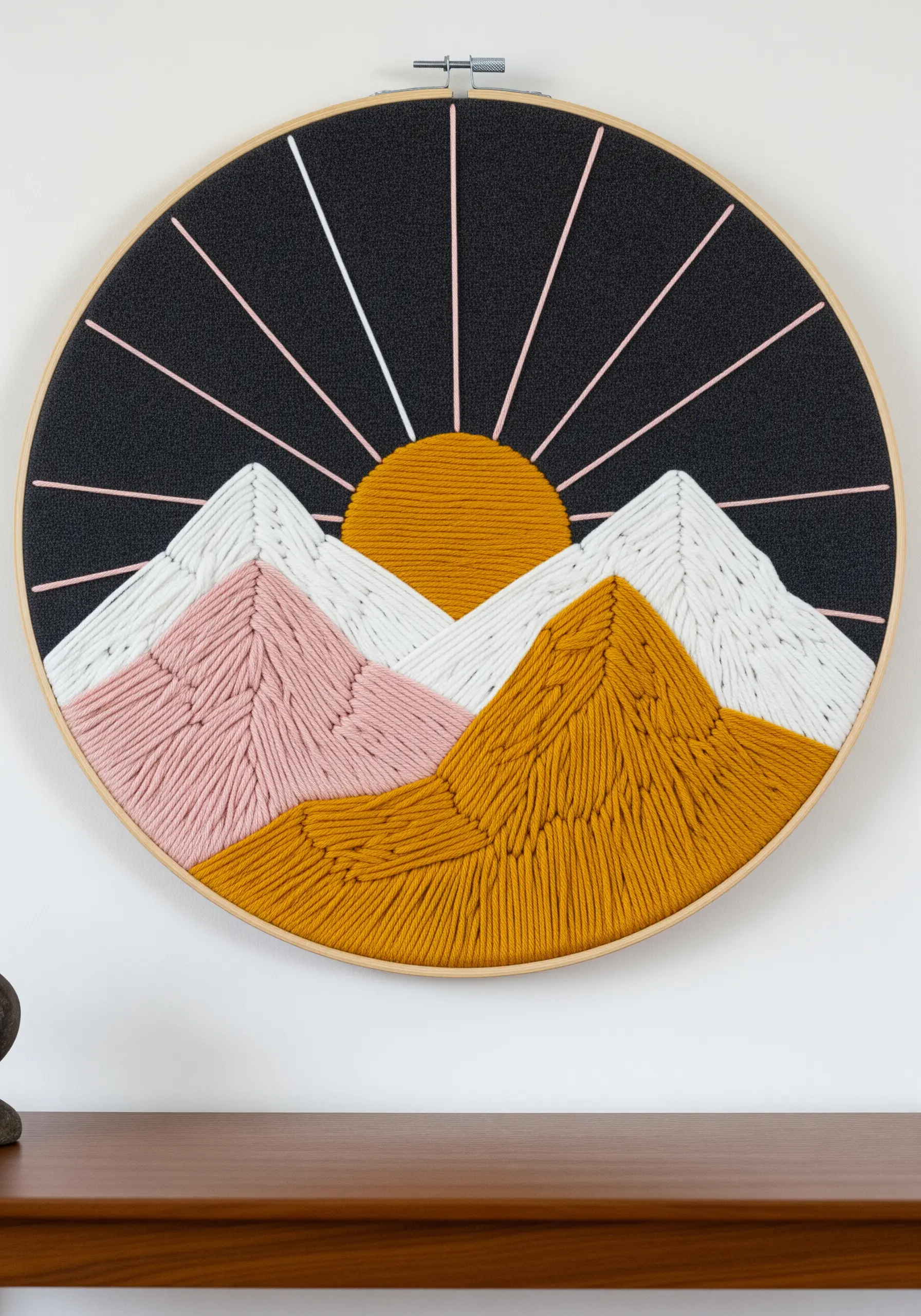 A stylized mountain landscape in a large hoop, using thick yarn and directional satin stitch.