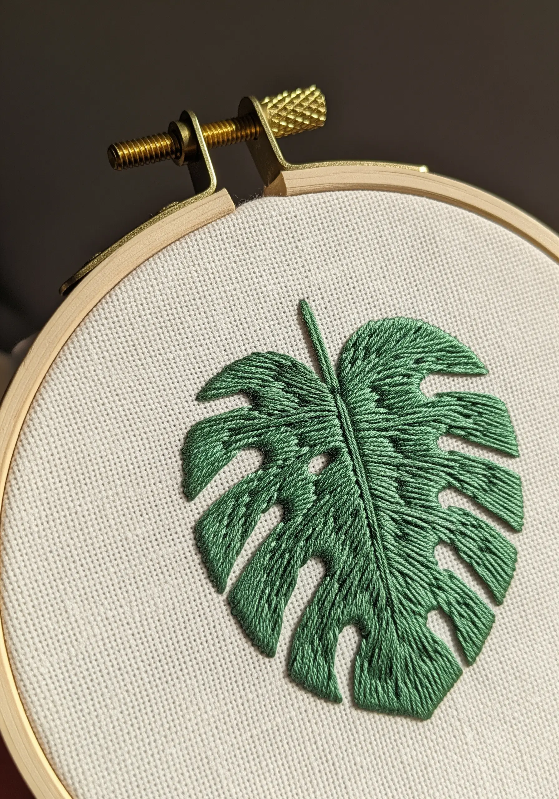 A green monstera leaf filled with directional satin stitch to create a realistic texture.